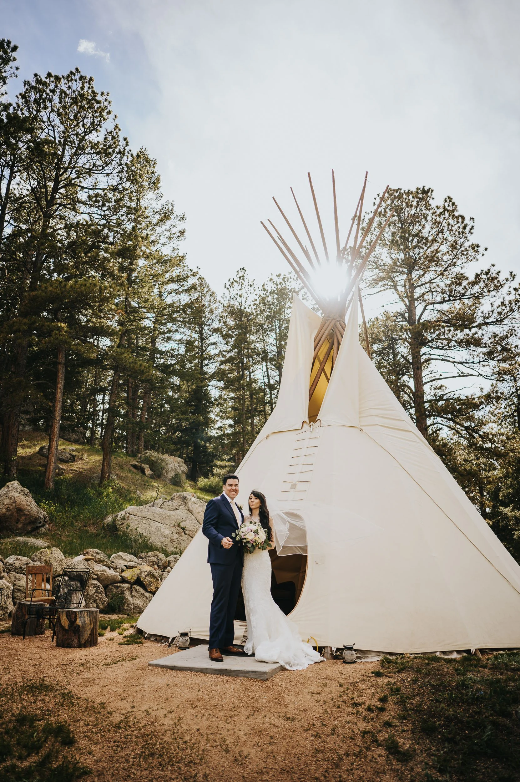 Couple posing for photos outside the teepee at Younger Ranch wedding venue in Colorado Springs.