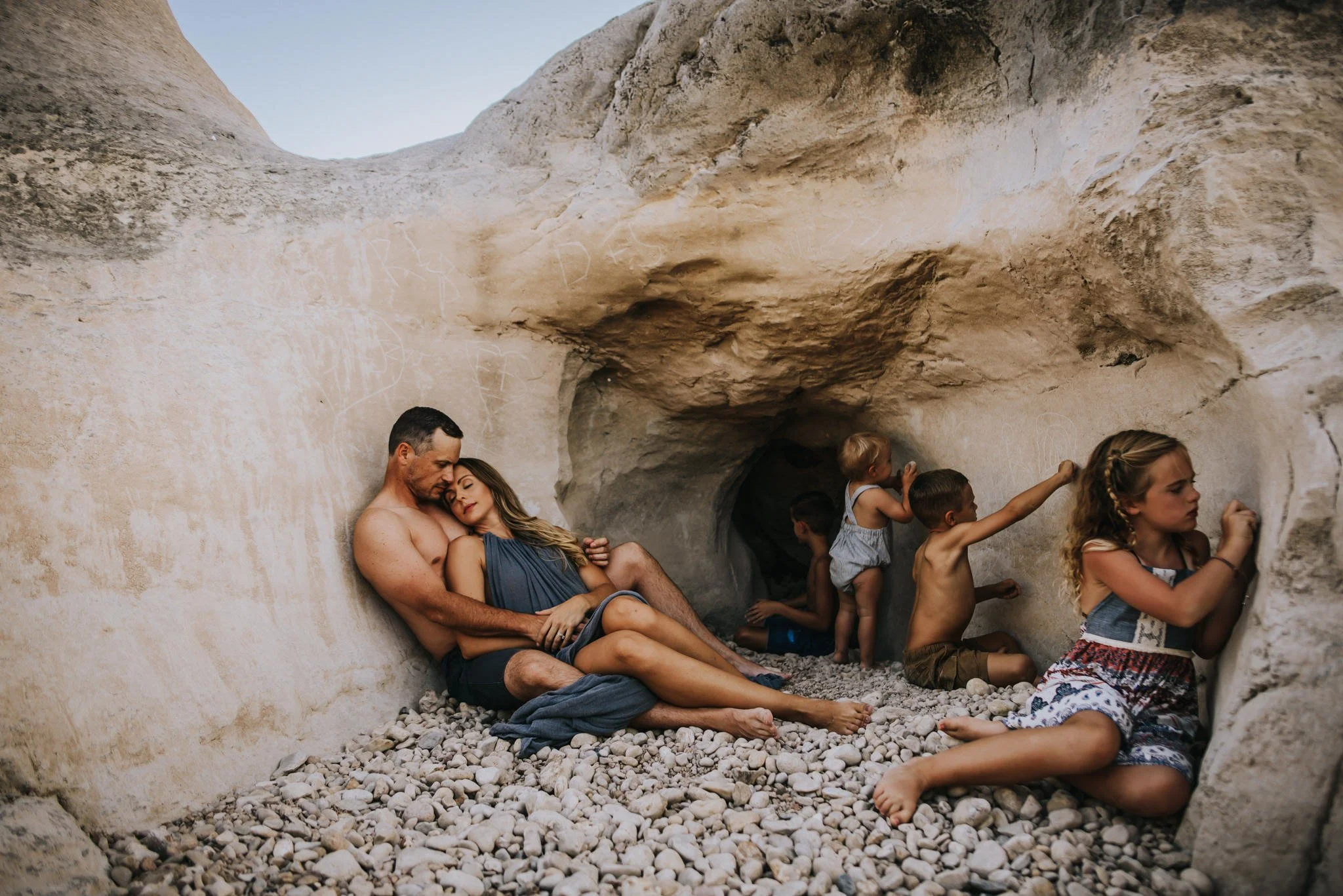 Documentary-style family photo showing parents and children together outdoors, capturing connection across different stages of childhood.