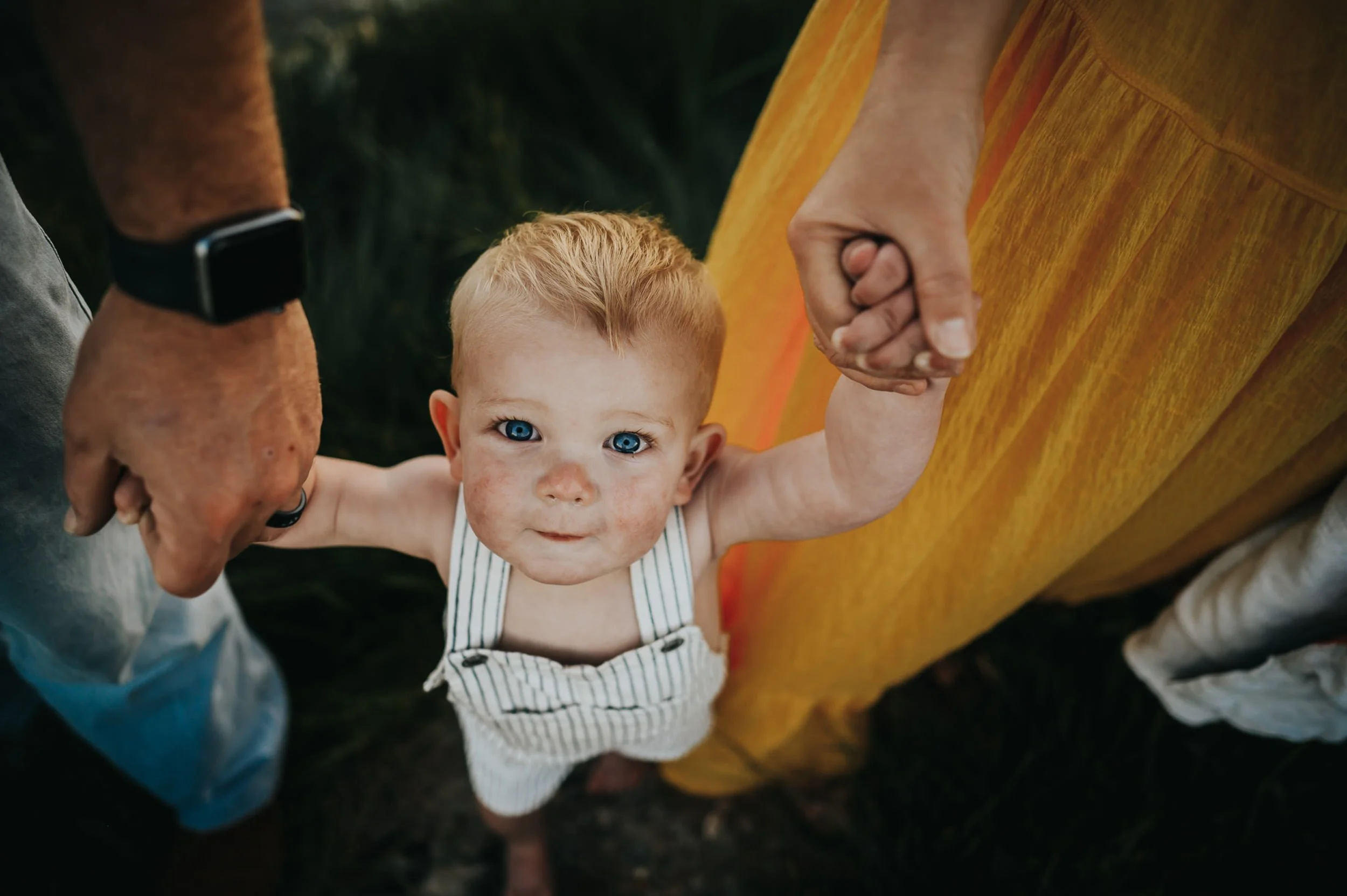 blue-eyed-boy-looks-up-striped-overalls.jpg