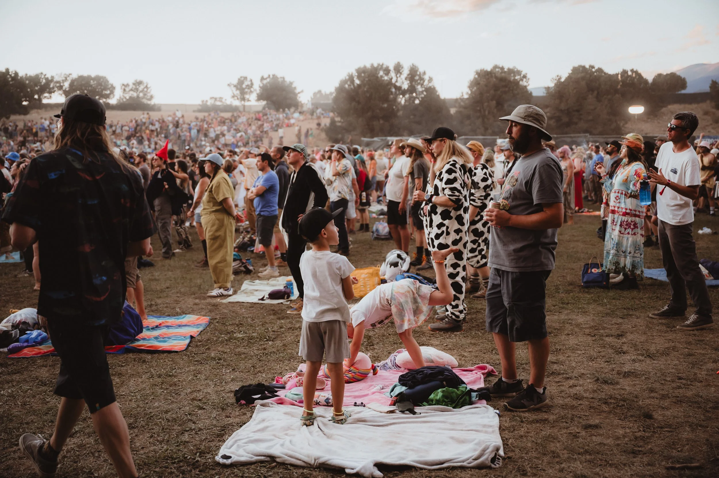 Family enjoying King Gizzard from a blanket at Field of Vision festival Meadow Creek.