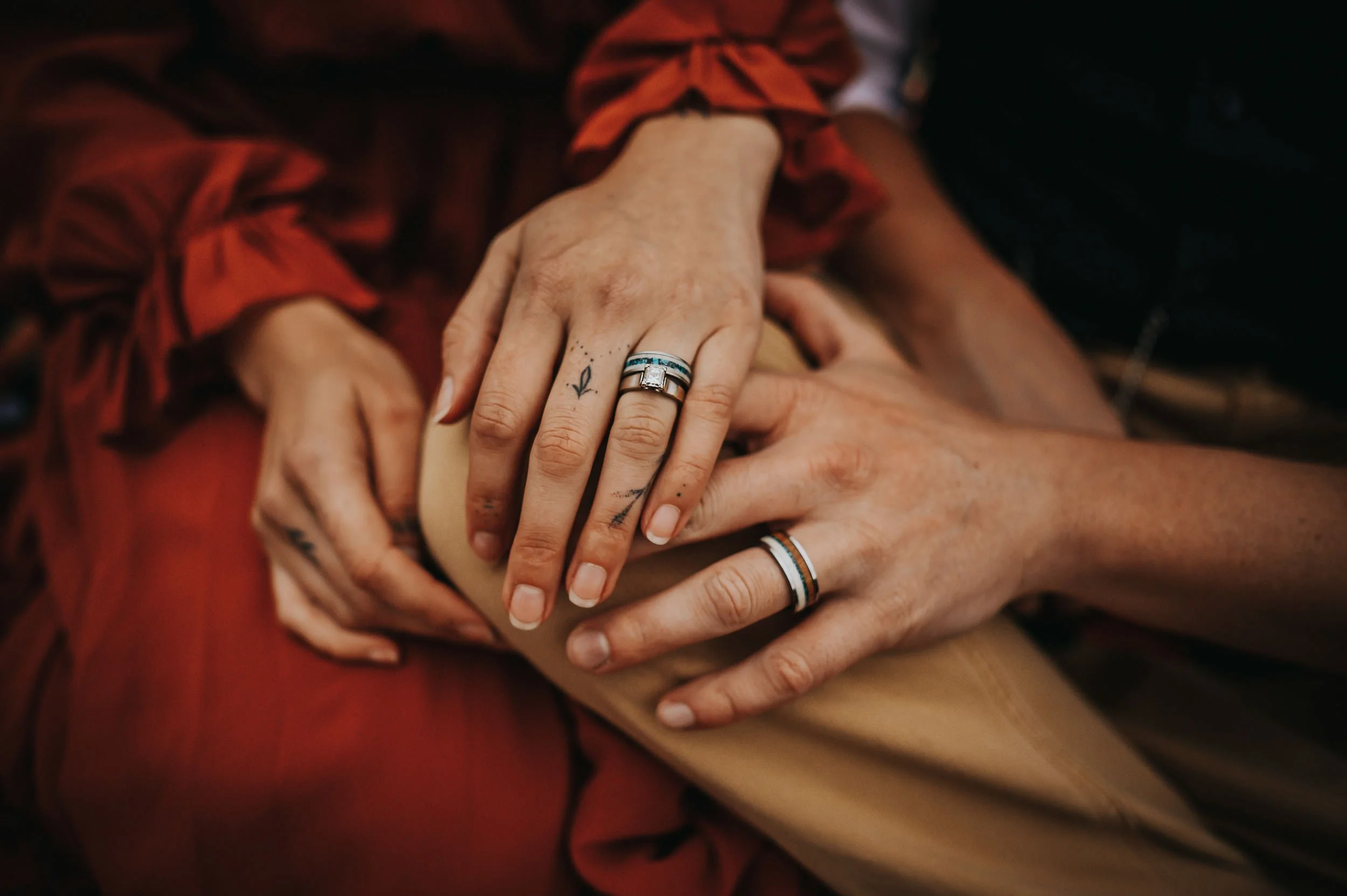 Detail shot of couple's hands showing chunky vintage silver rings with turquoise stone, bohemian jewelry styling for couples photos.