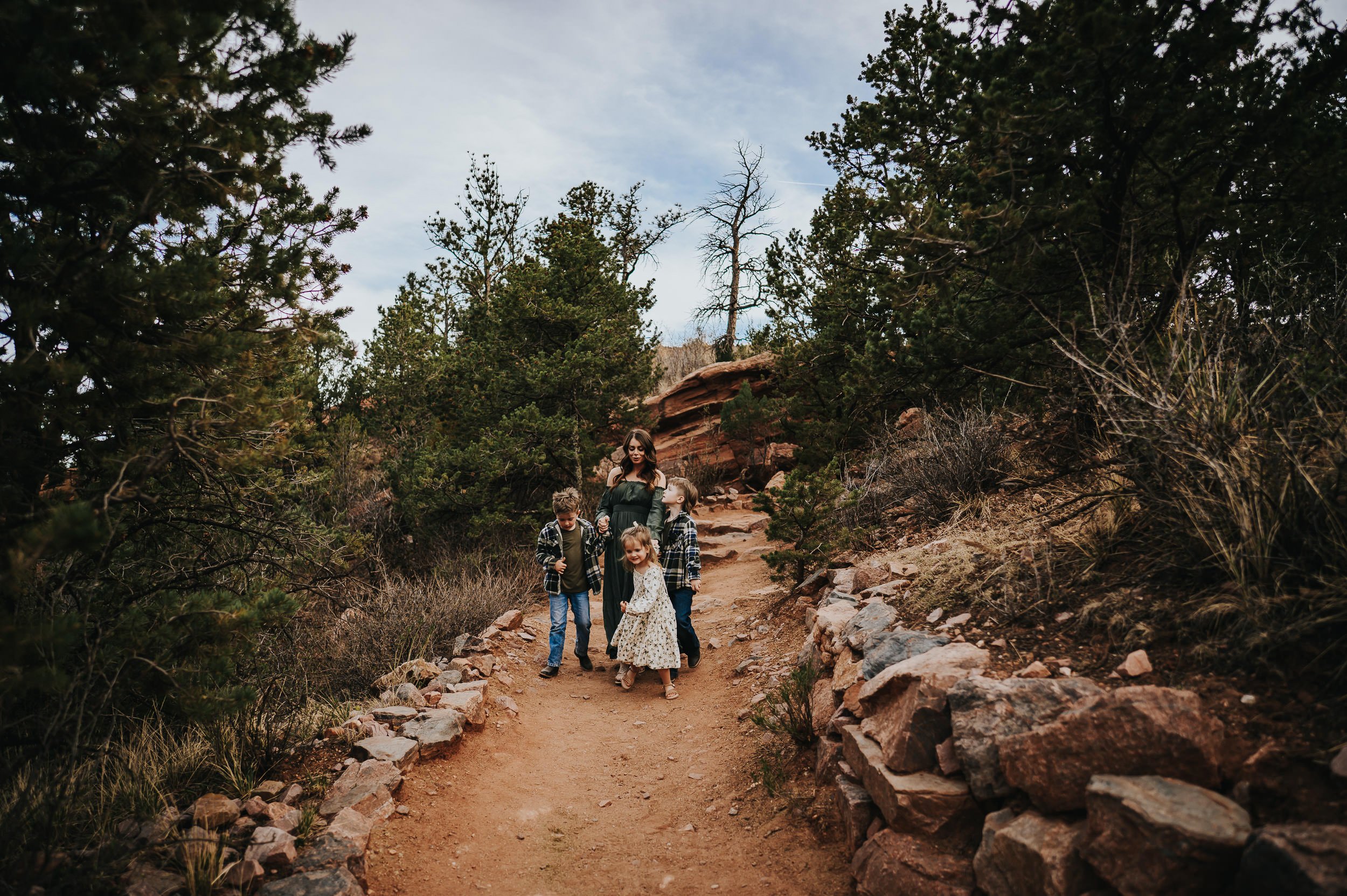 Family of four walking together down a path at Garden of the Gods.