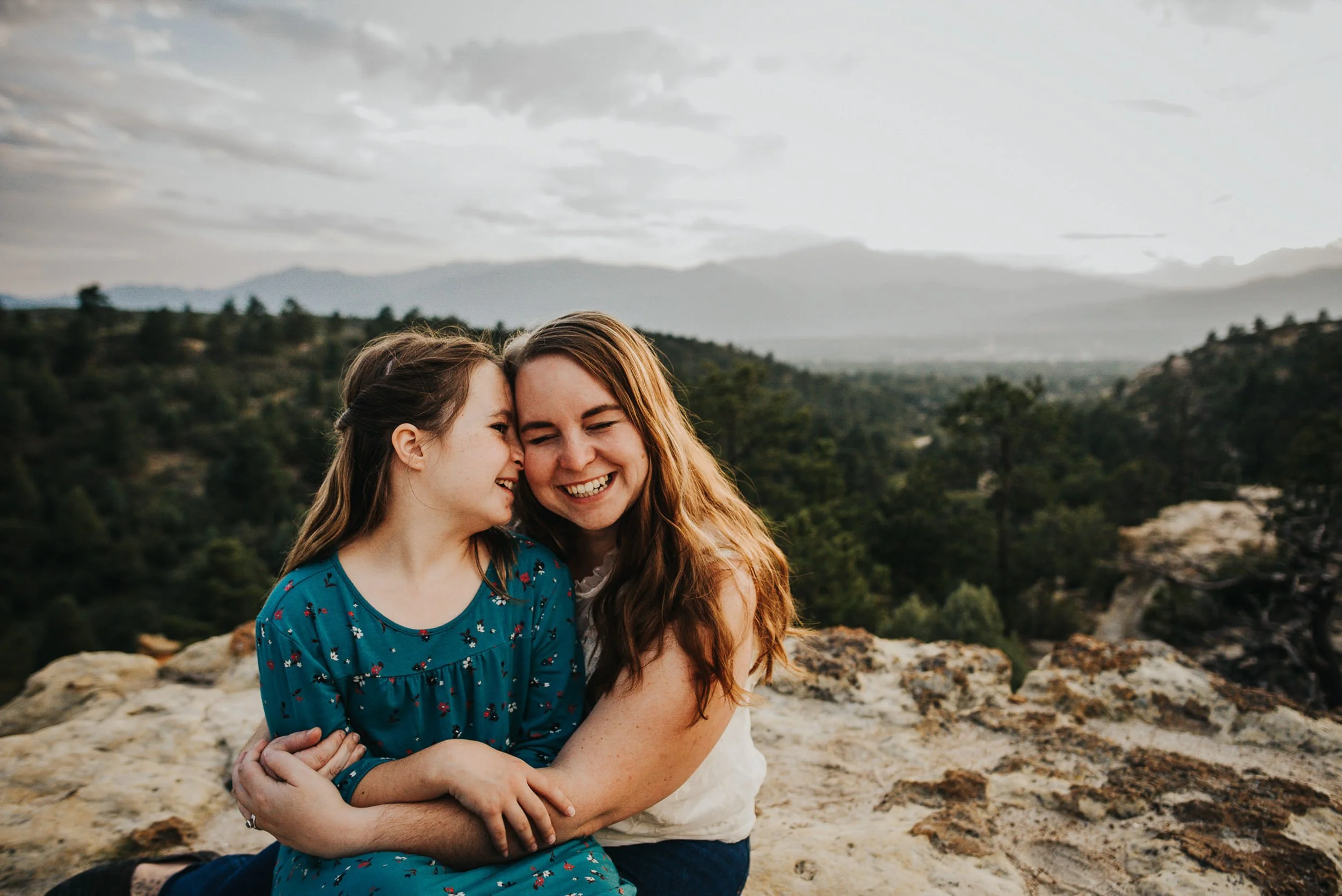 Mother and daughter embracing at Palmer Park with soft light through oak trees.