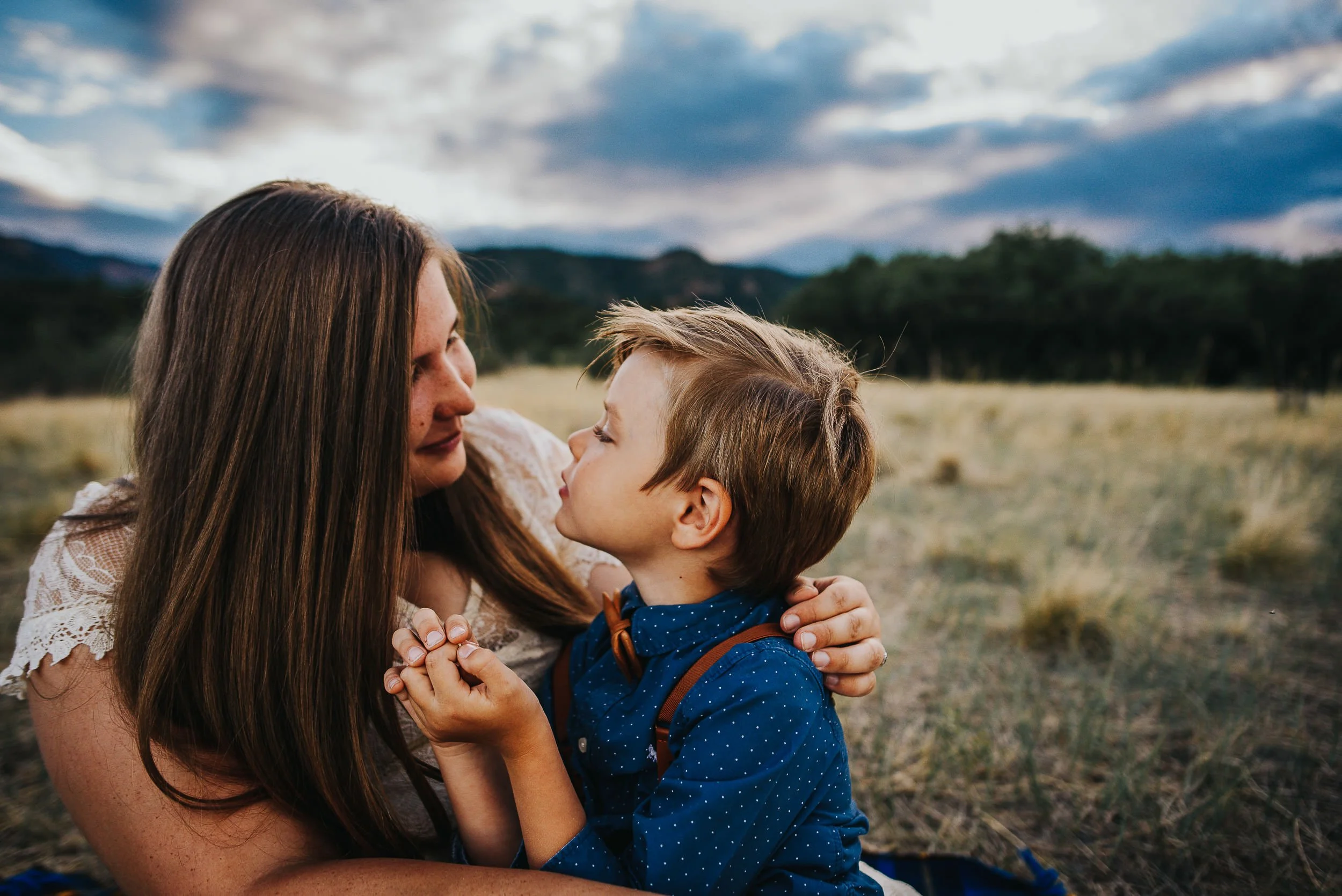 A mother and her son talk to each other and share wild flowers in a field in Colorado Springs.