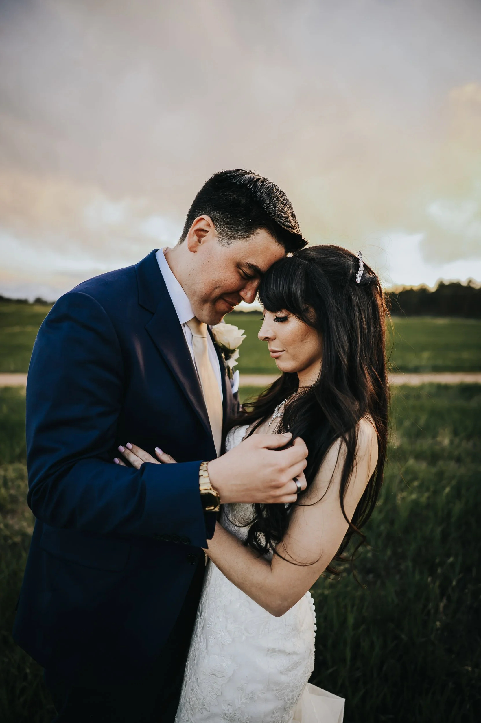 Newlyweds standing together at Younger Ranch with Pikes Peak behind them.