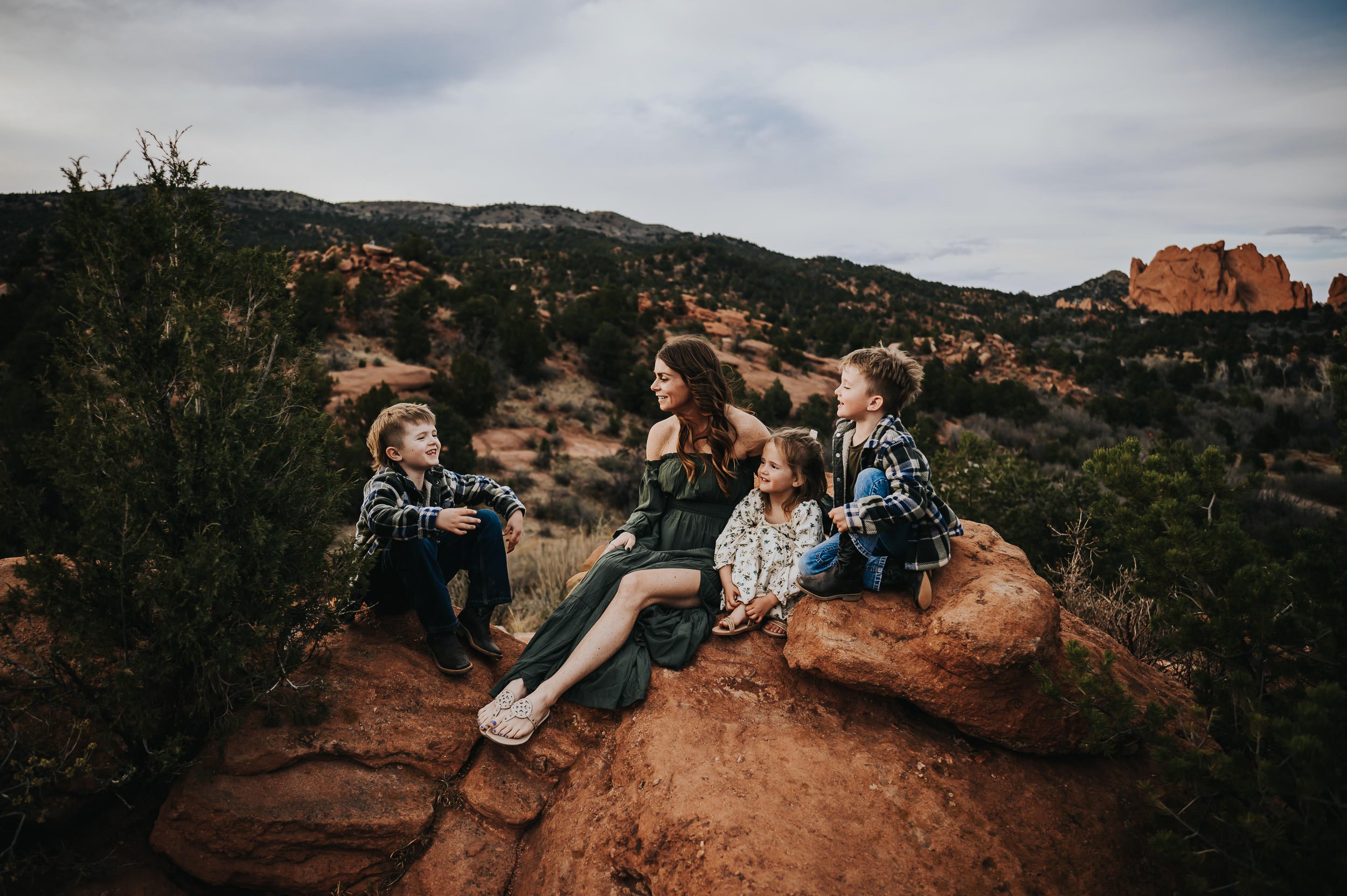 Family sitting together with dramatic Garden of the Gods formations in the background.