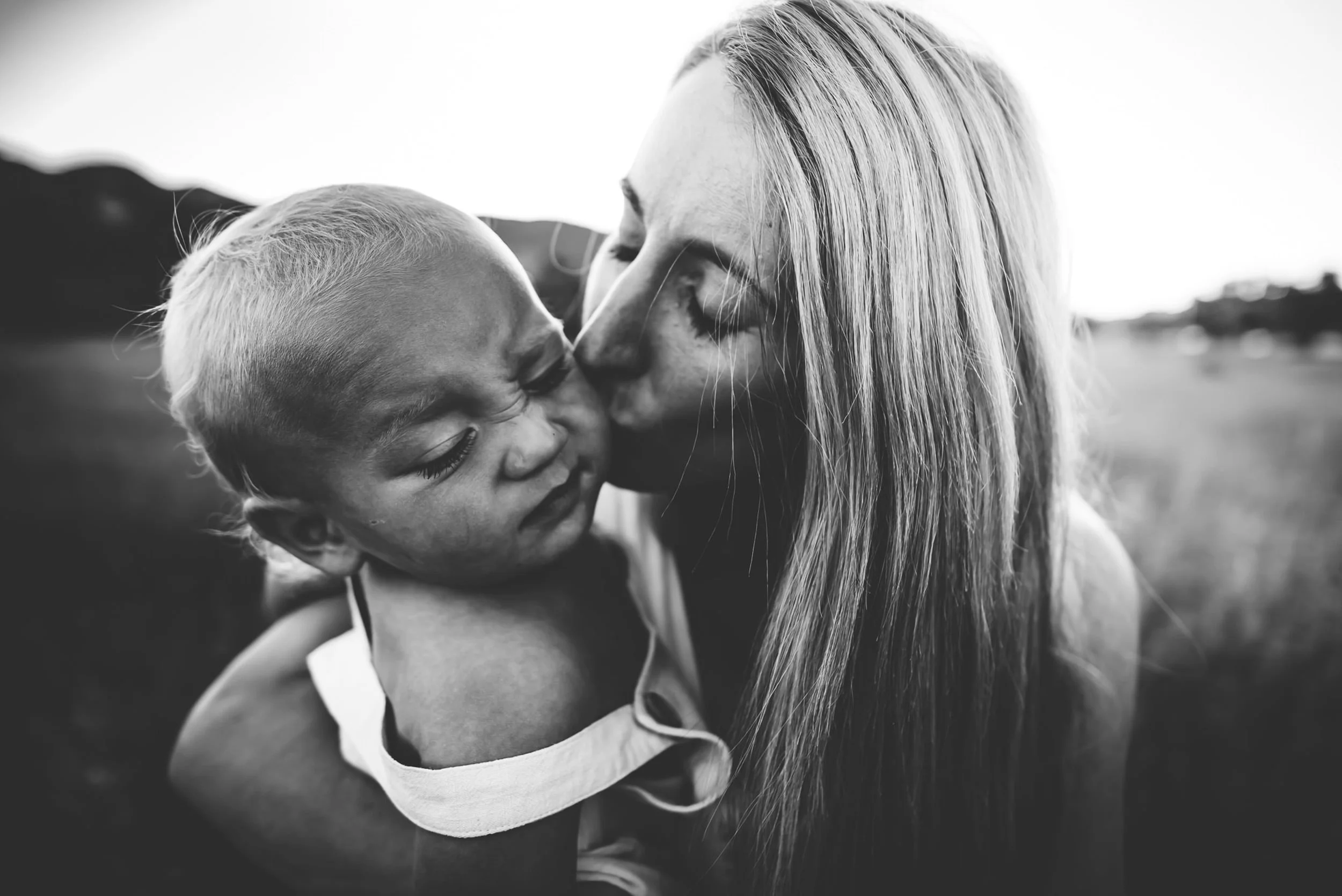 mom-mountain-field-bw-closeup-kissing-son.jpg