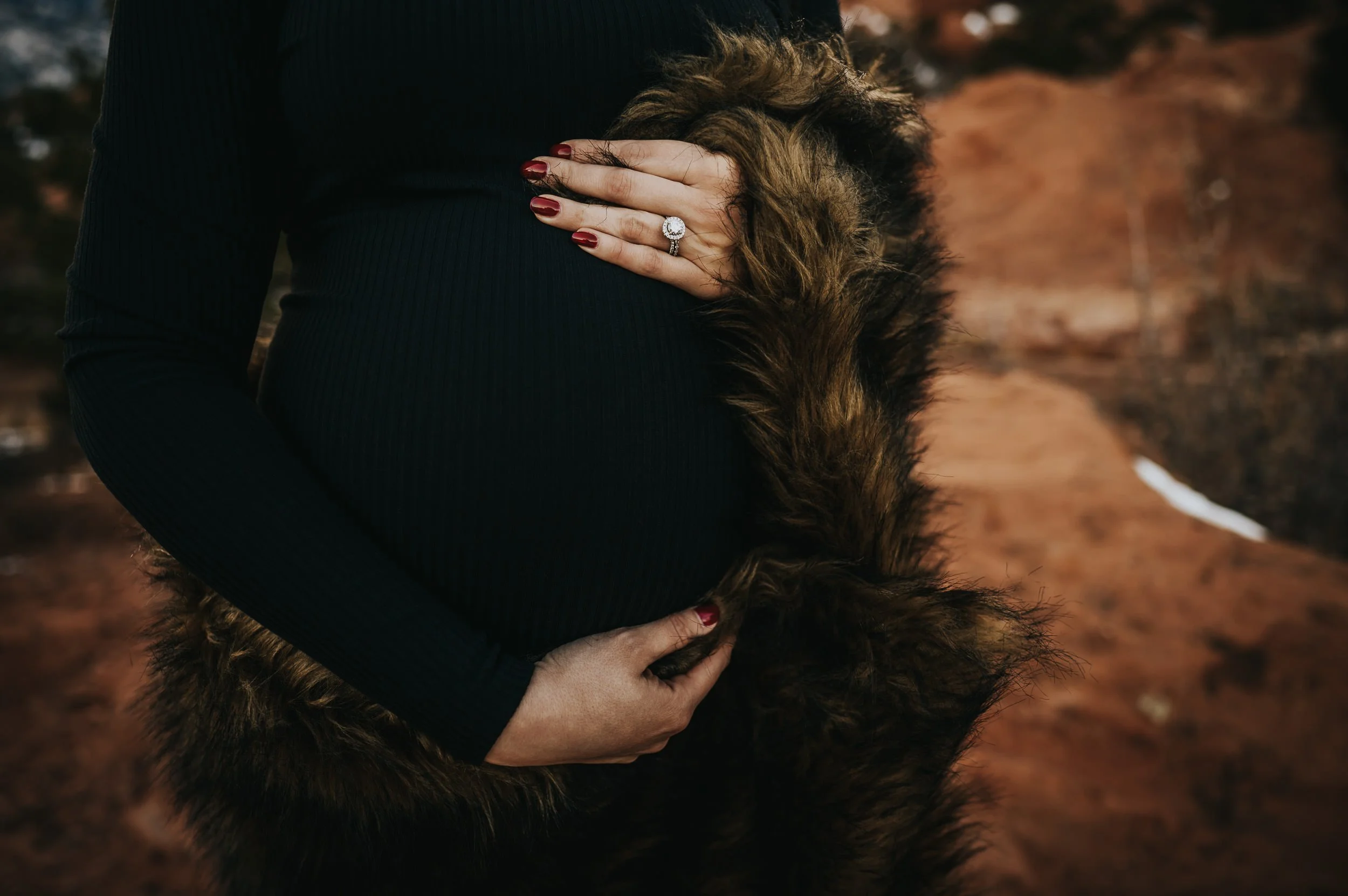 Maternity session at Garden of the Gods with warm sunset light on red rock formations.
