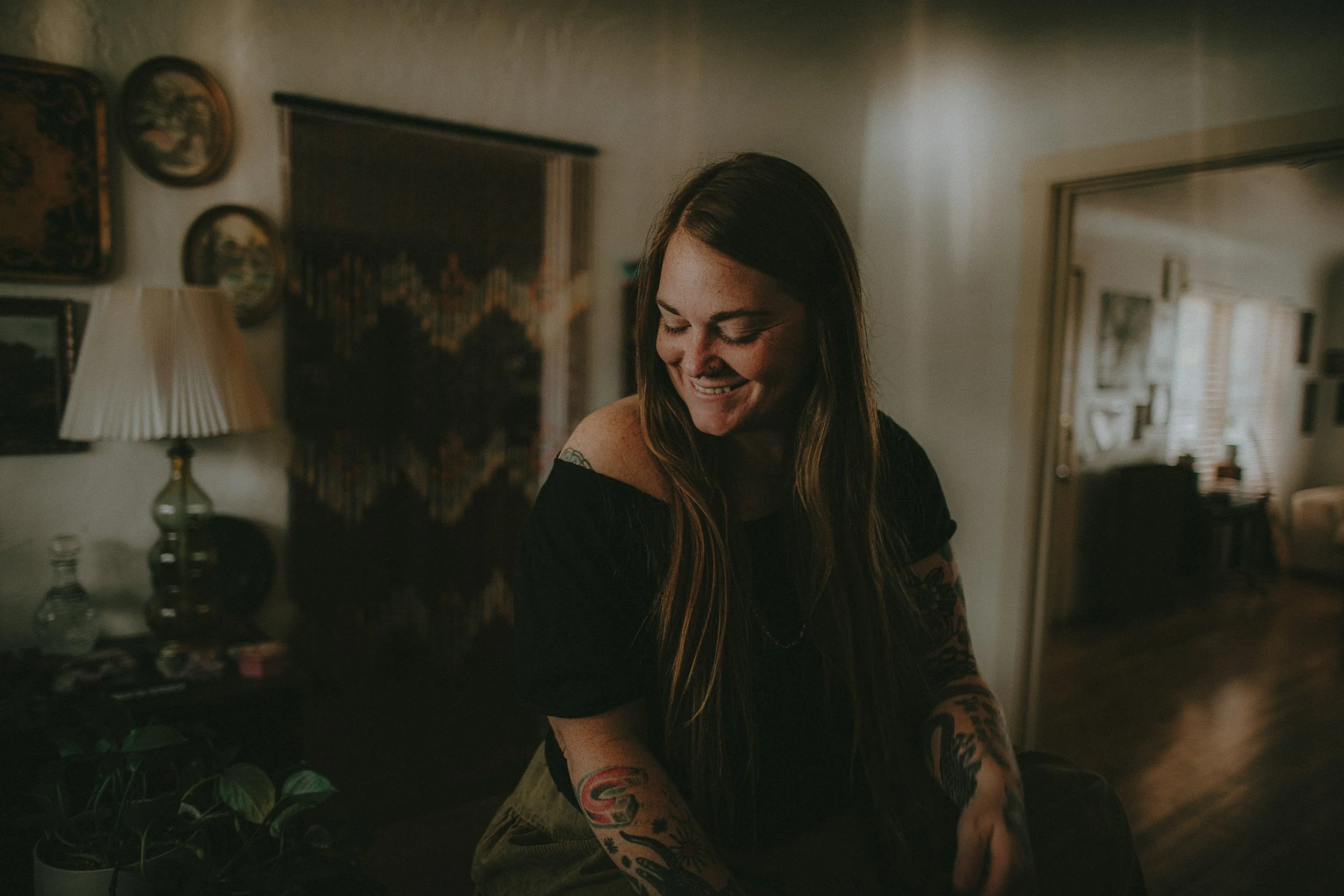 Sandy, Colorado Springs photographer, laughing in a warm indoor portrait.