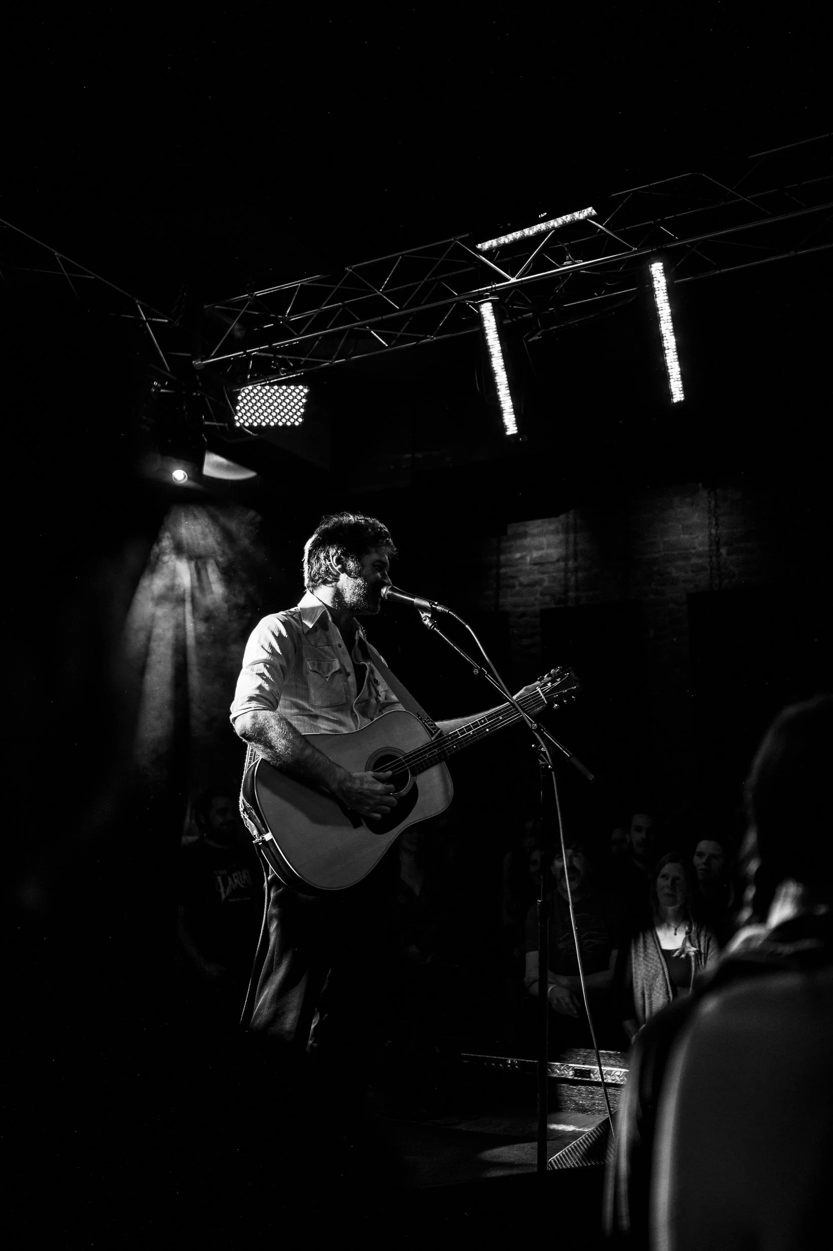 Close-up of John Craigie singing on stage at The Lariat in Buena Vista.