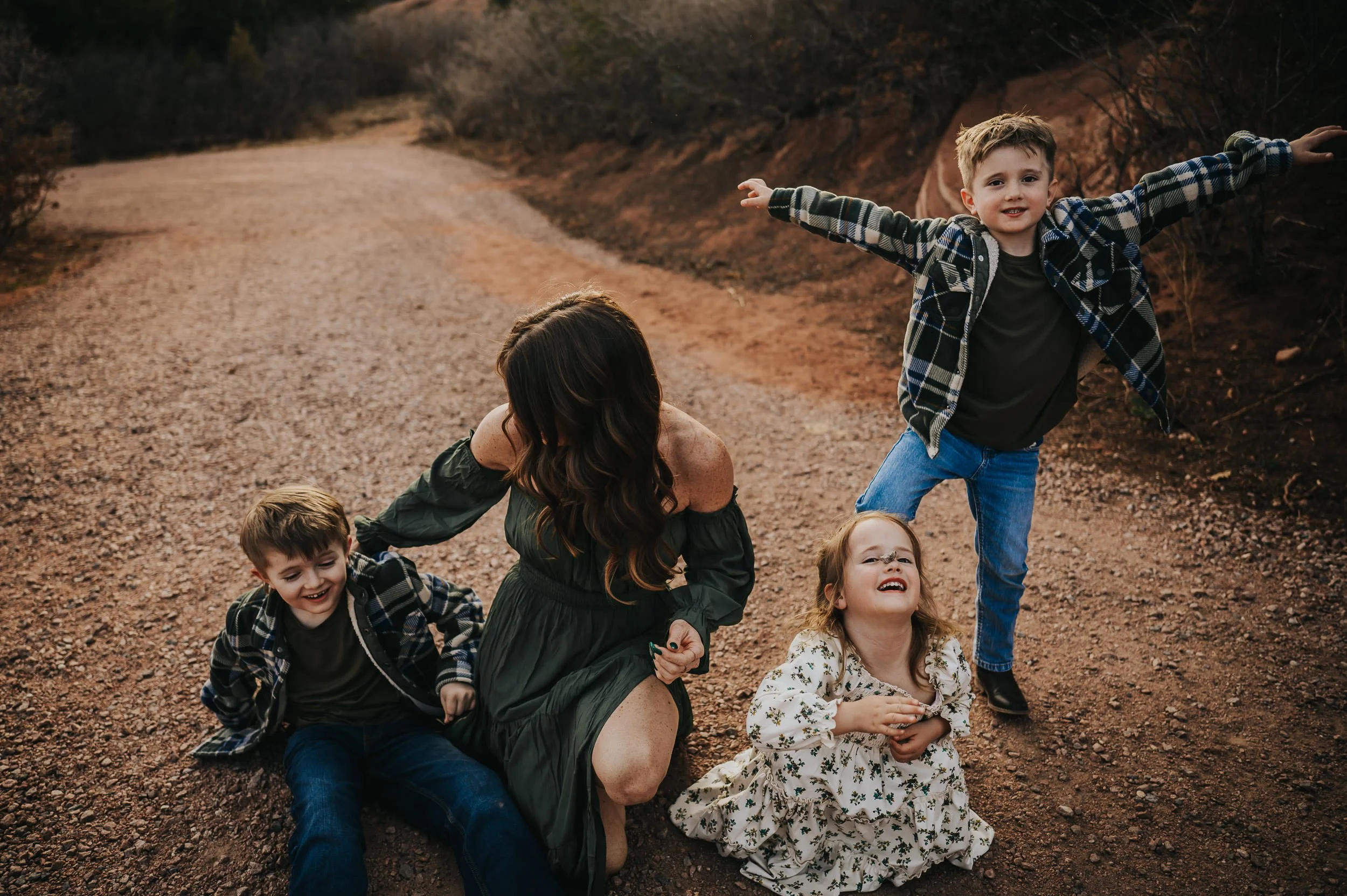 Big brother with arms spread wide, playing with his sibling.