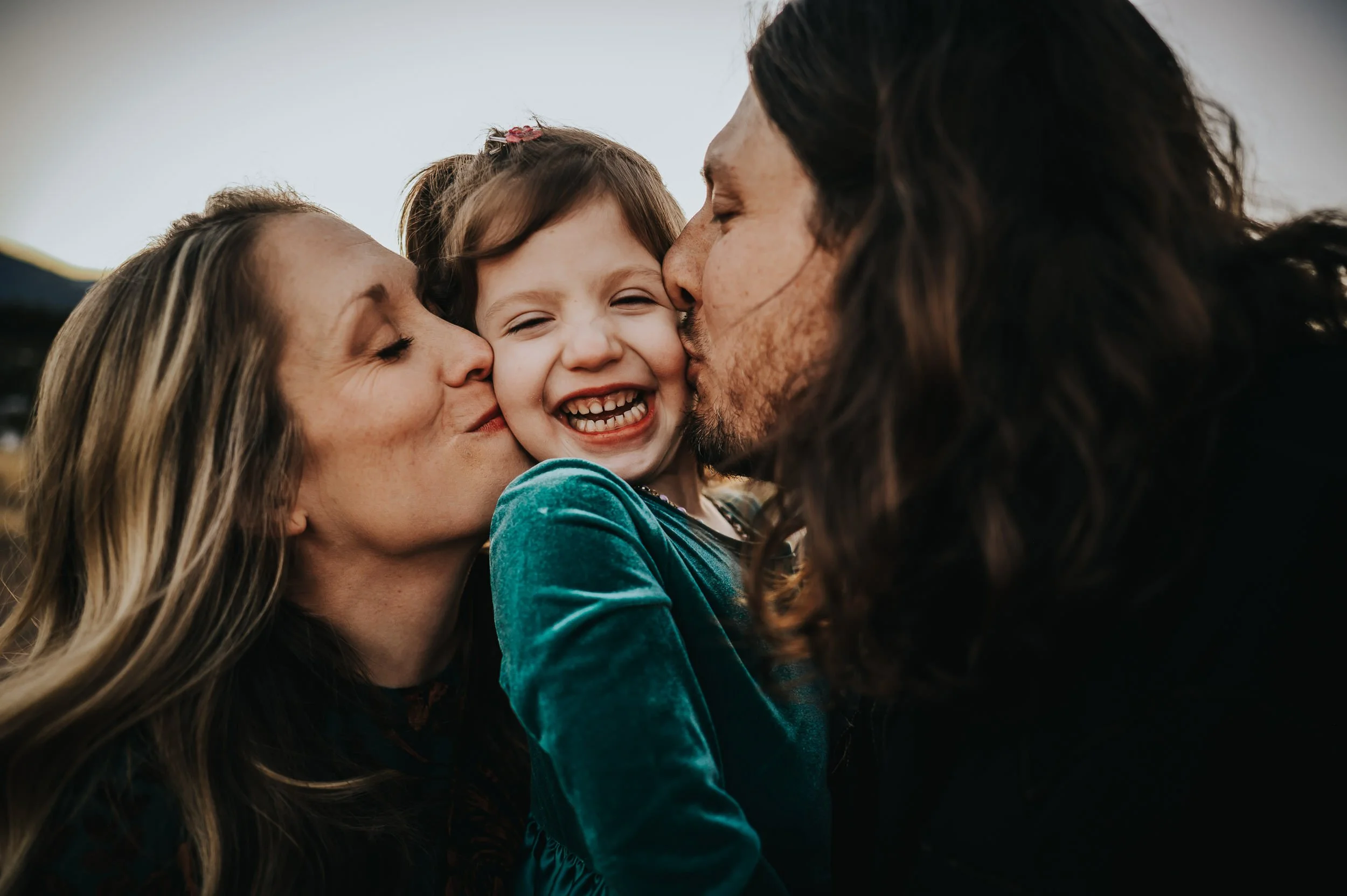 Expecting family sharing a quiet moment during a mountain maternity session