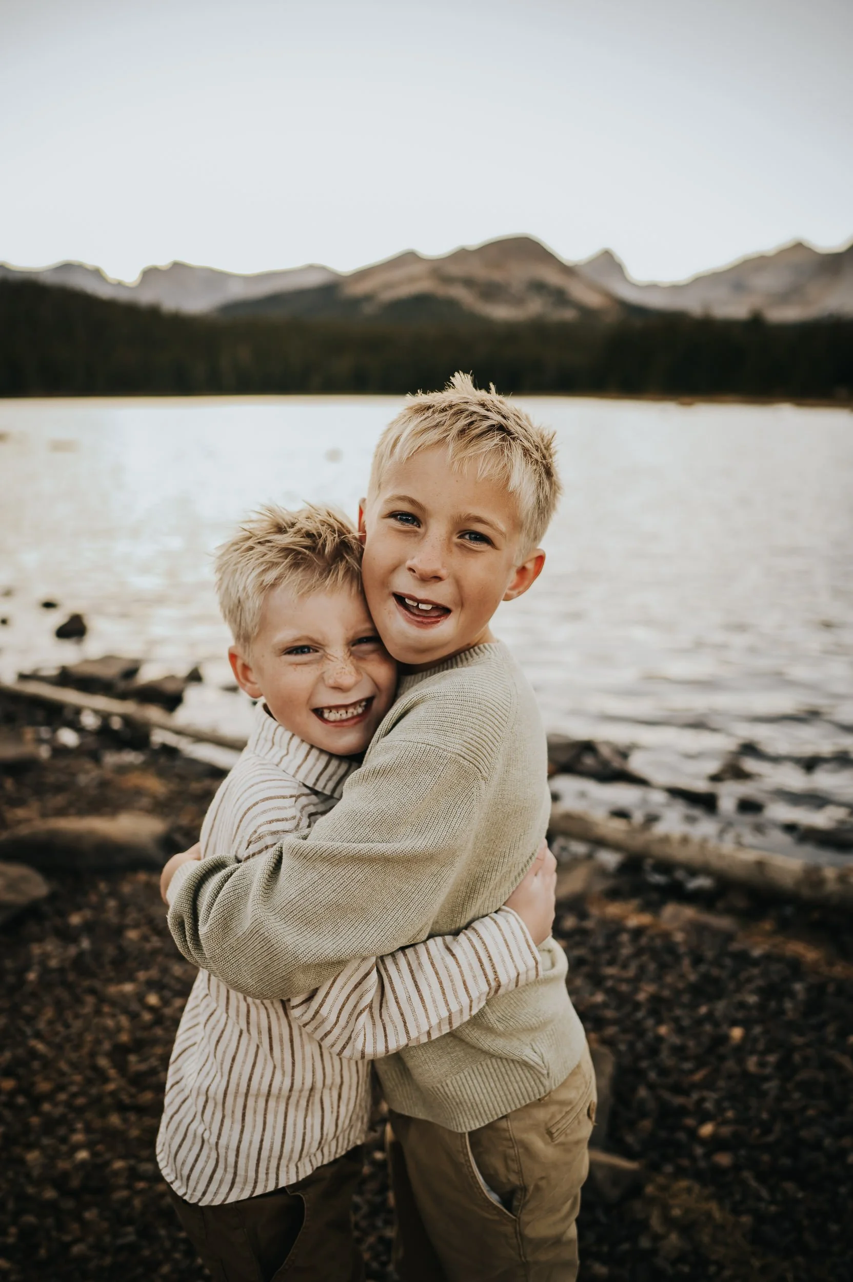 Family standing together as the sun sets behind the mountains at Brainard Lake in Colorado.