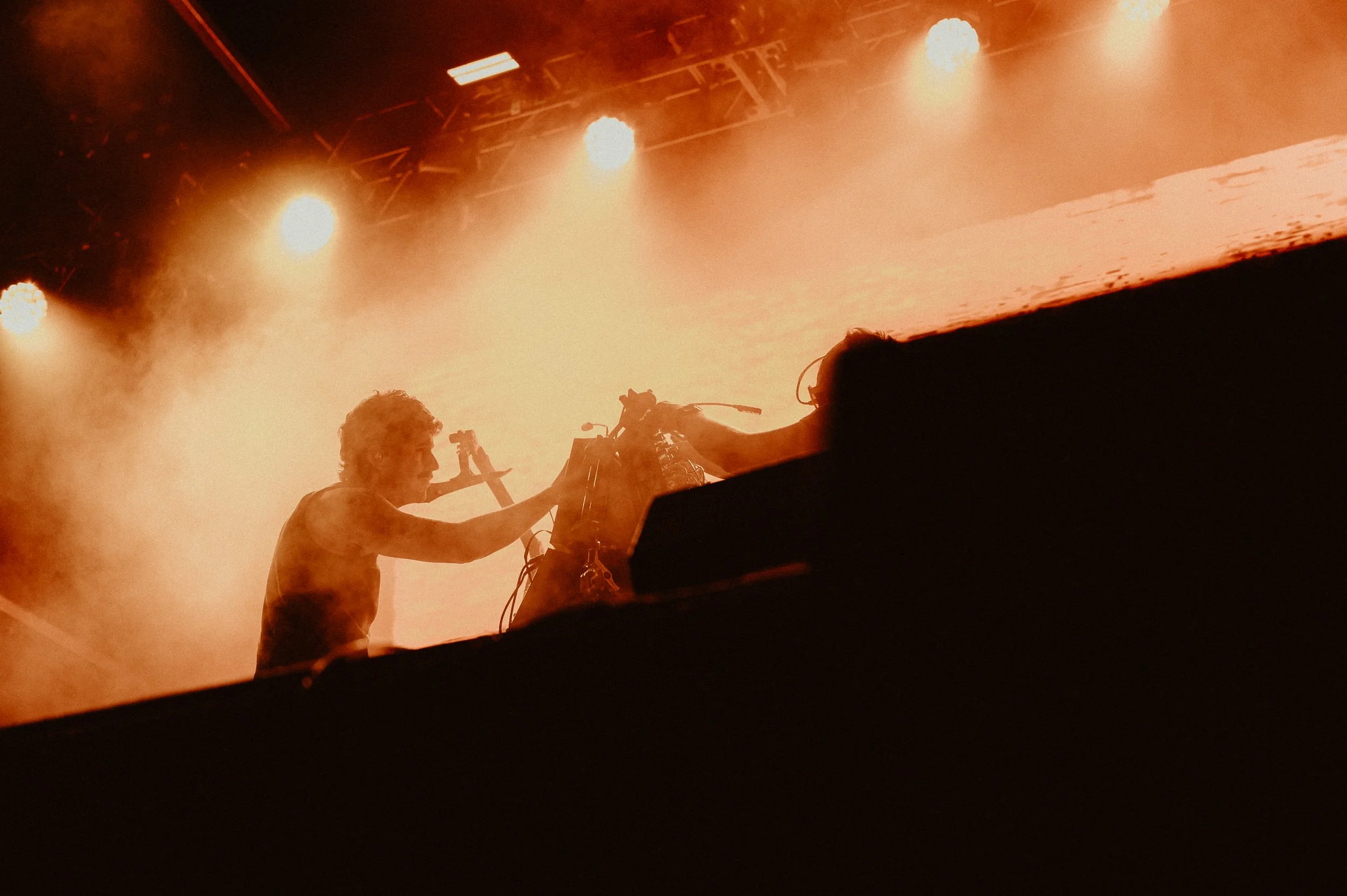 Musician in spotlight during Field of Vision festival performance.