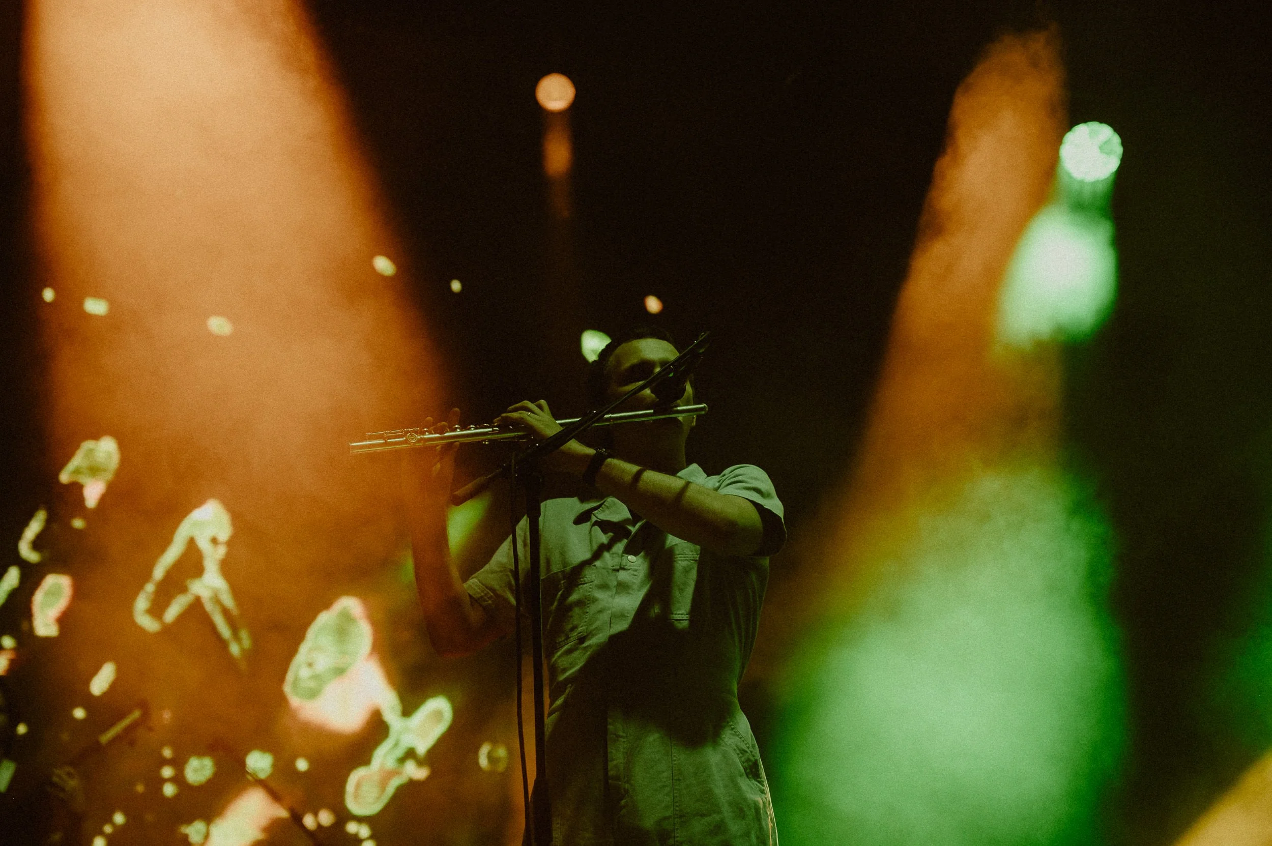 Stu Mackenzie playing flute during Empty at Field of Vision with colorful stage lighting.