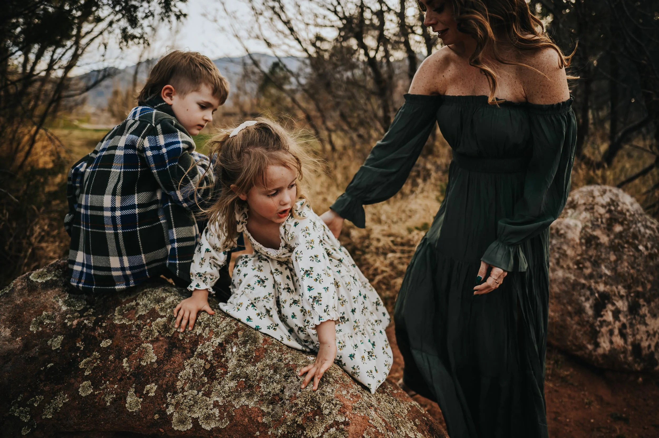 Mom crouching down with her daughter, both looking at something on the ground.