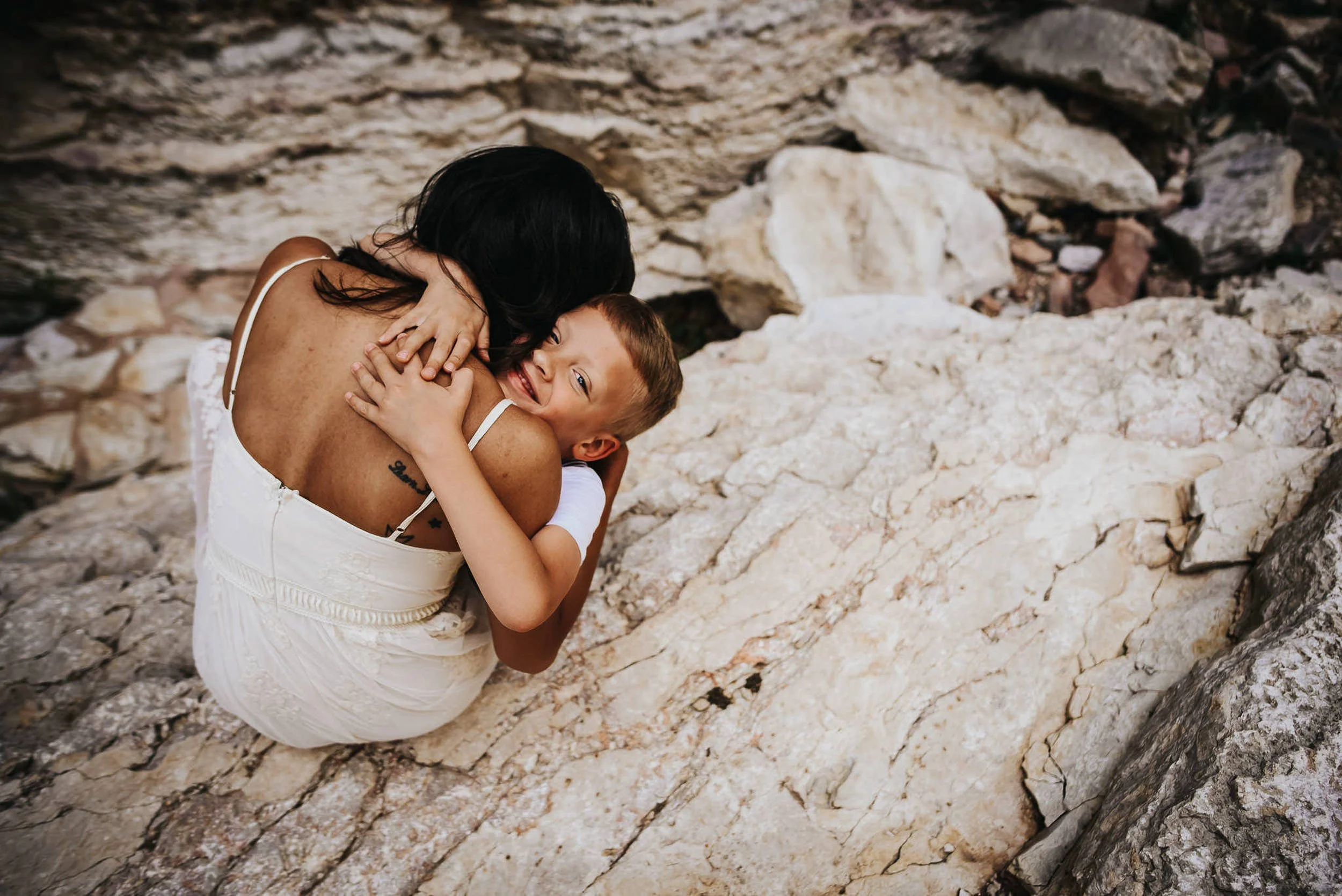 boy-hugs-mom-on-white-rocks.jpg