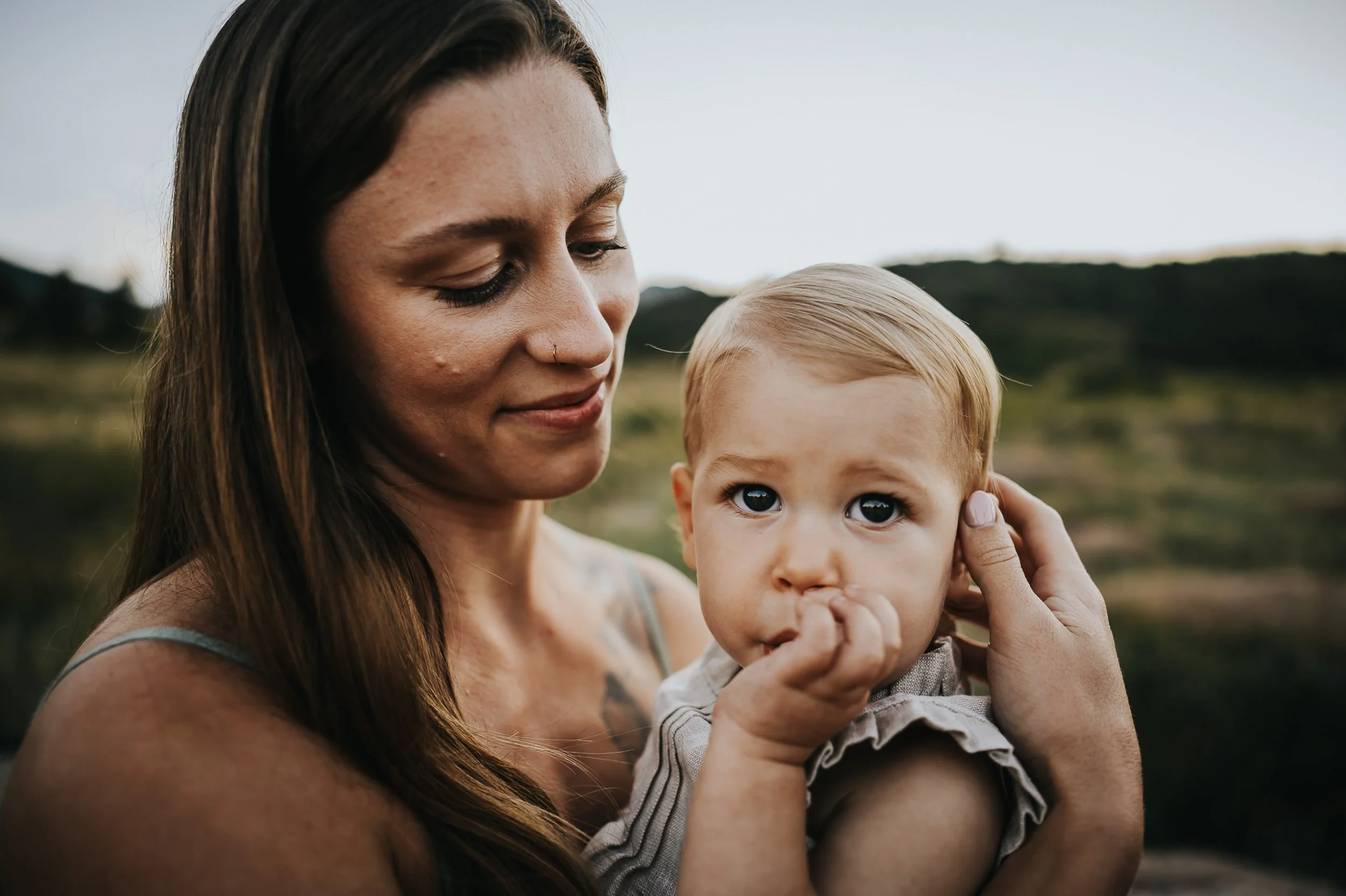 Mother gazing softly at her toddler in warm natural outdoor light.