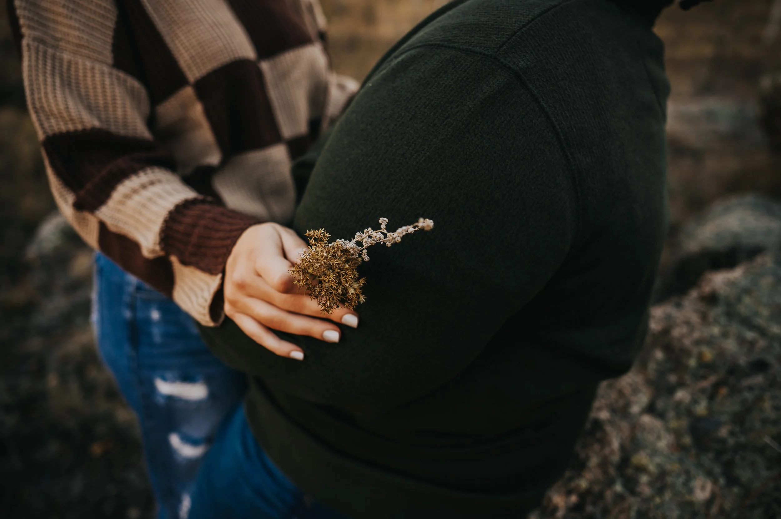 Two women walking hand in hand through tall golden grasses before their Colorado elopement.
