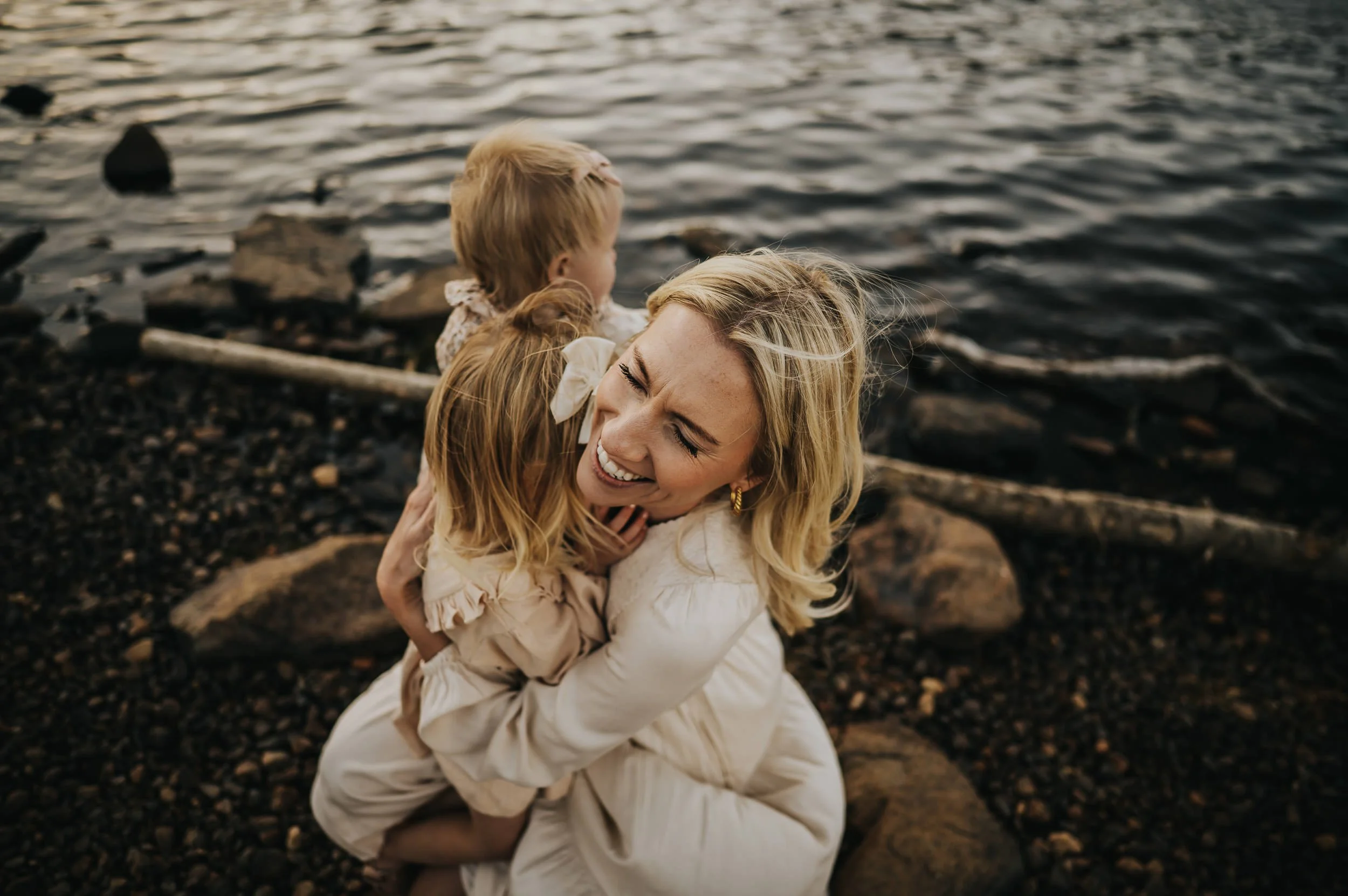 Family standing together at Brainard Lake during golden hour with Rocky Mountain peaks behind them.