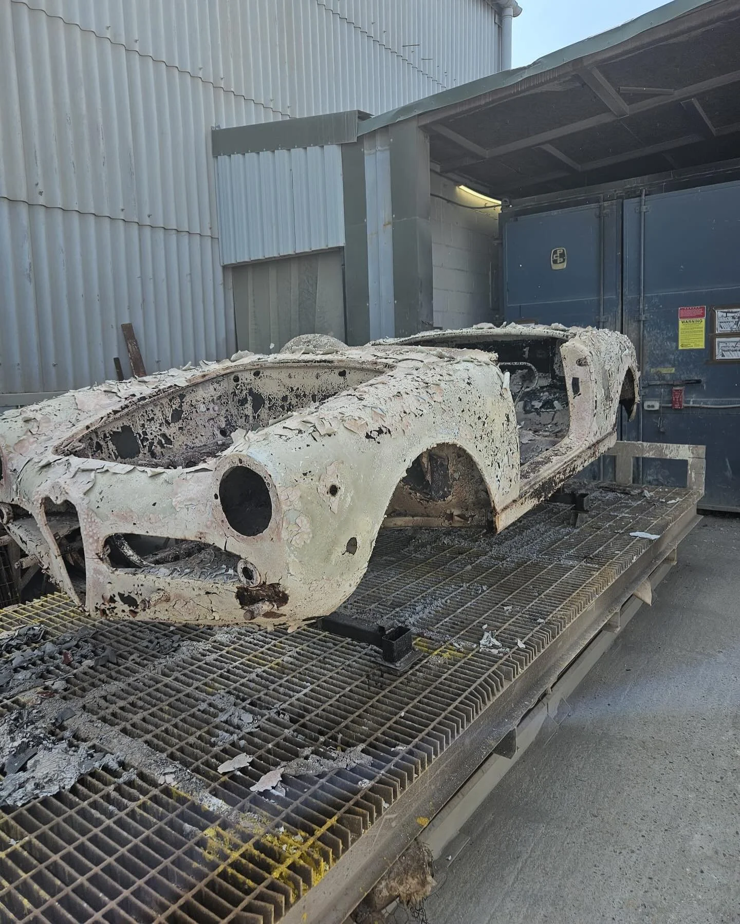 A 101-series Alfa Romeo Spider stripped and rusty body at the beginning of a complete restoration.