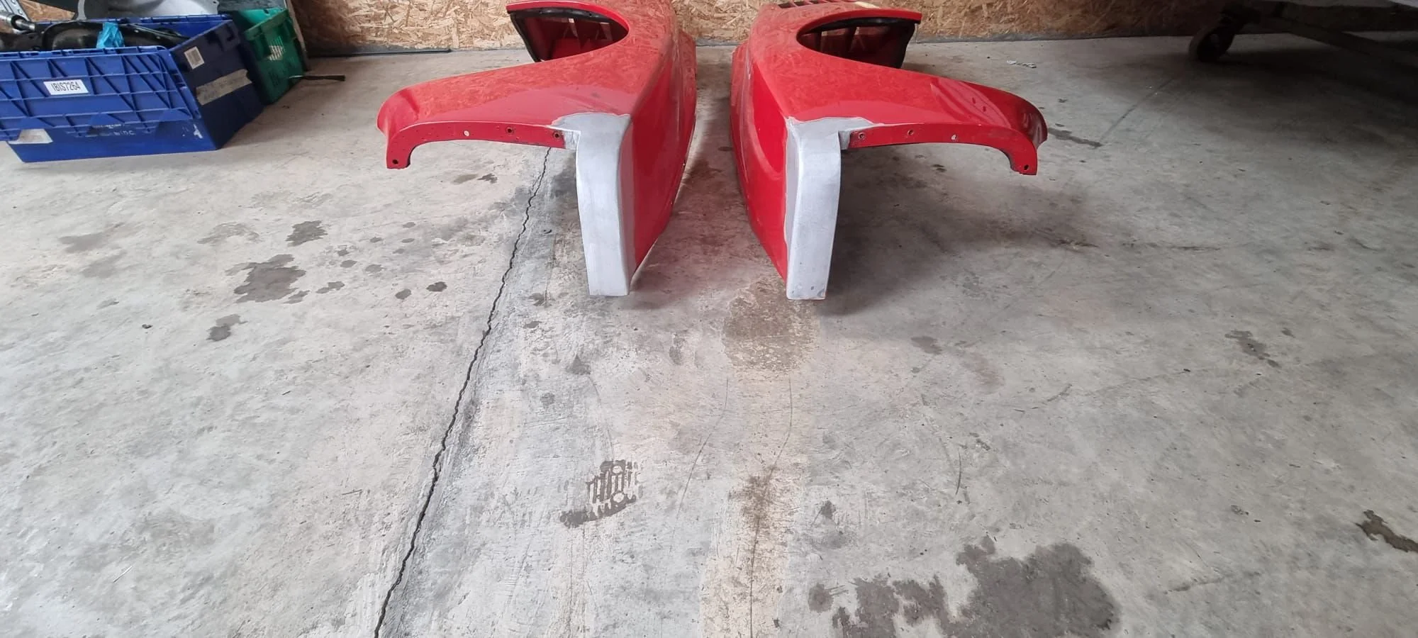 Two red Ferrari Testarossa fenders that underwent repairs.