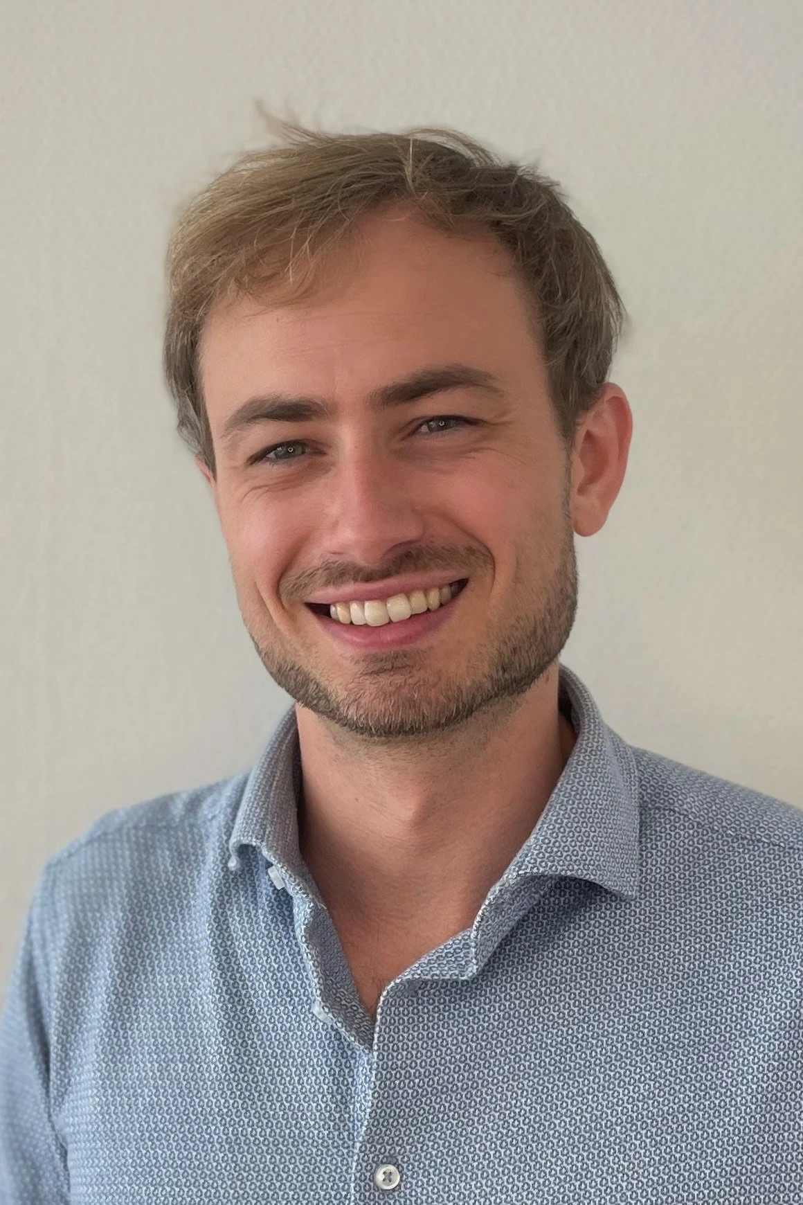 A profile of a smiling man with brown hair