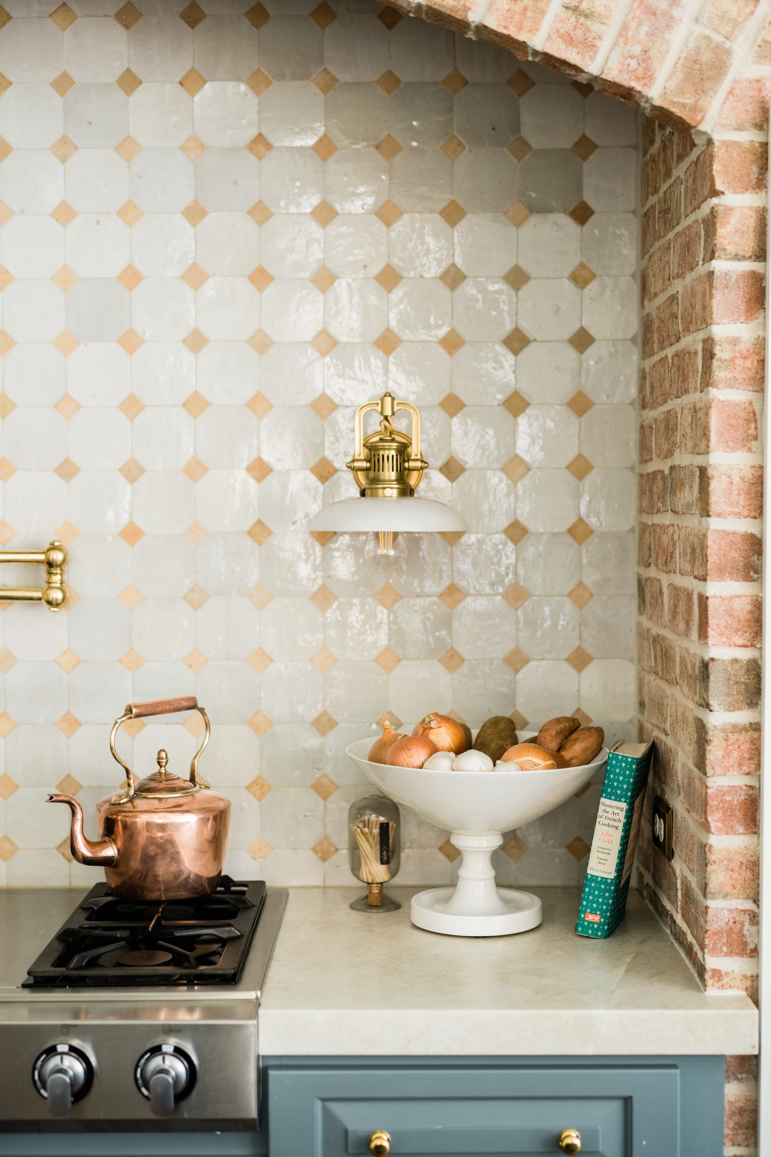 Kitchen with brick walls and tile backsplash with wall sconce
