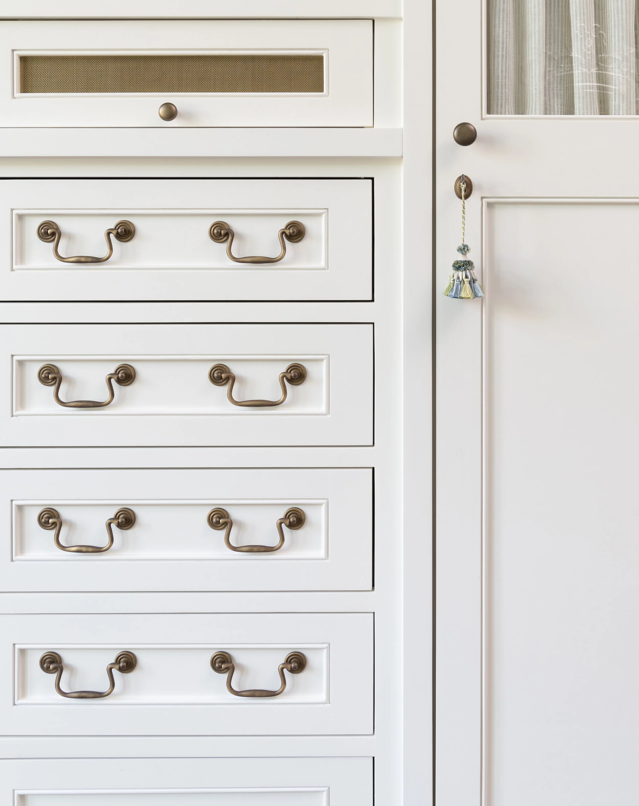 Custom wardrobe and antique brass hardware. Traditional millwork details and passatemarri by Samuel & Sons. Designed by Sherrell Neal, principal and founder of Sherrell Design Studio.