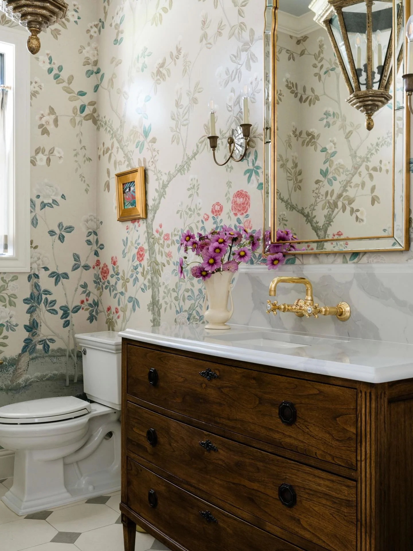 First impressions are everything! And powder rooms are where a home can show a little personality. Guests step in and immediately understand the tone of the house.

Here, the mural sets the scene, the custom dresser brings warmth, and the brass keeps