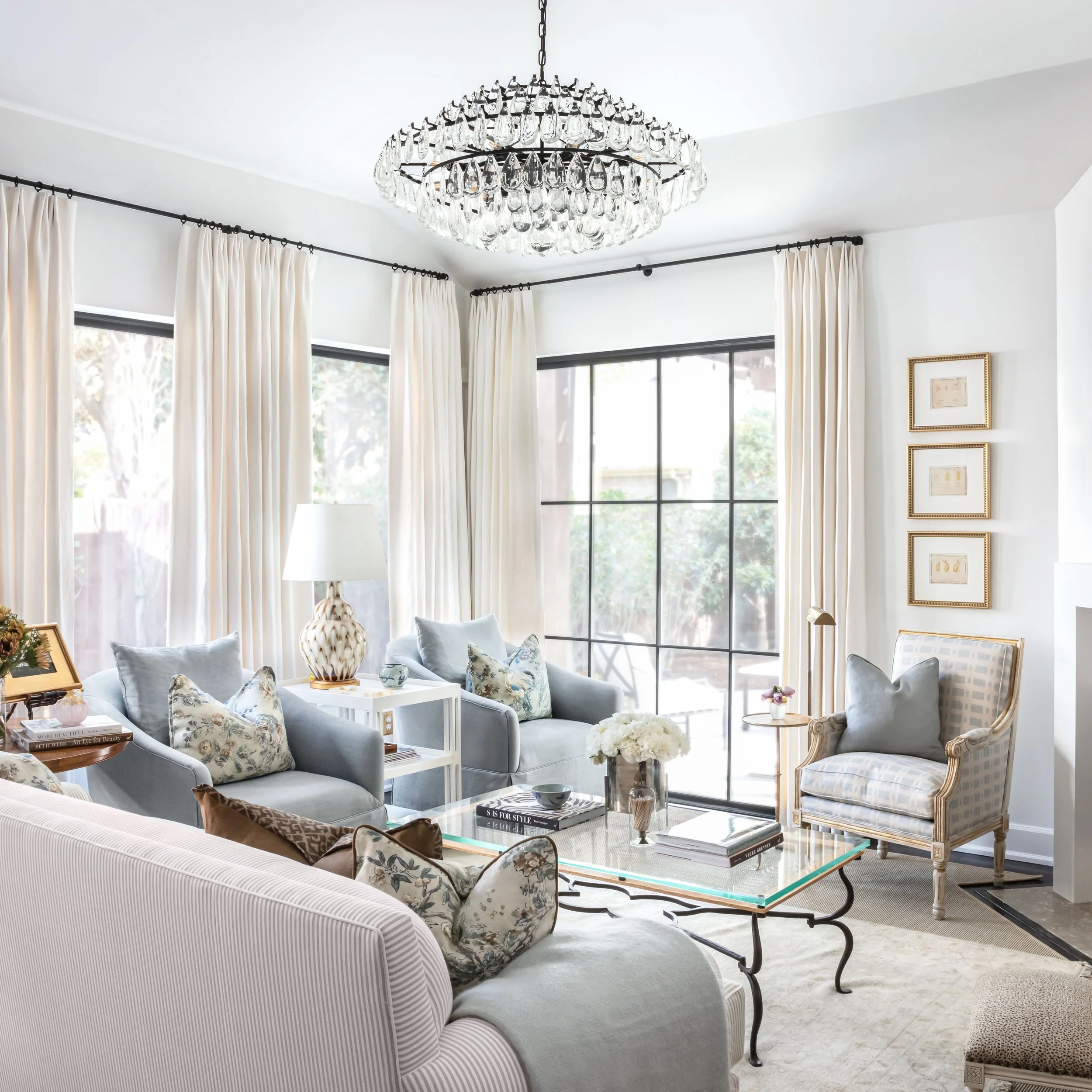 Soaring windows, a crystal chandelier that catches every hour of daylight differently, and a seating arrangement in soft blues and creams that never competes with the view outside. Some rooms are finished the moment you stop adding to them.
As seen i