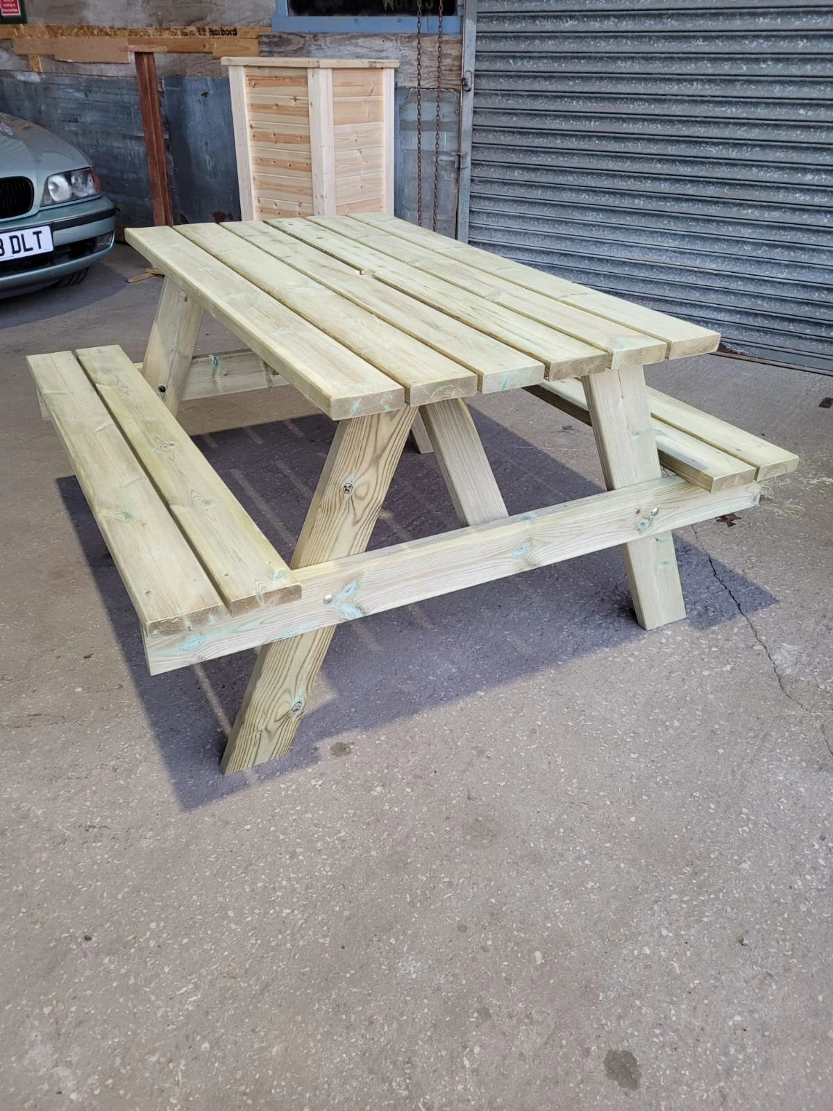 The Lathom picnic bench made of Scandinavian redwood by Bench and Bale in West Lancashire, on a concreate surface outdoors