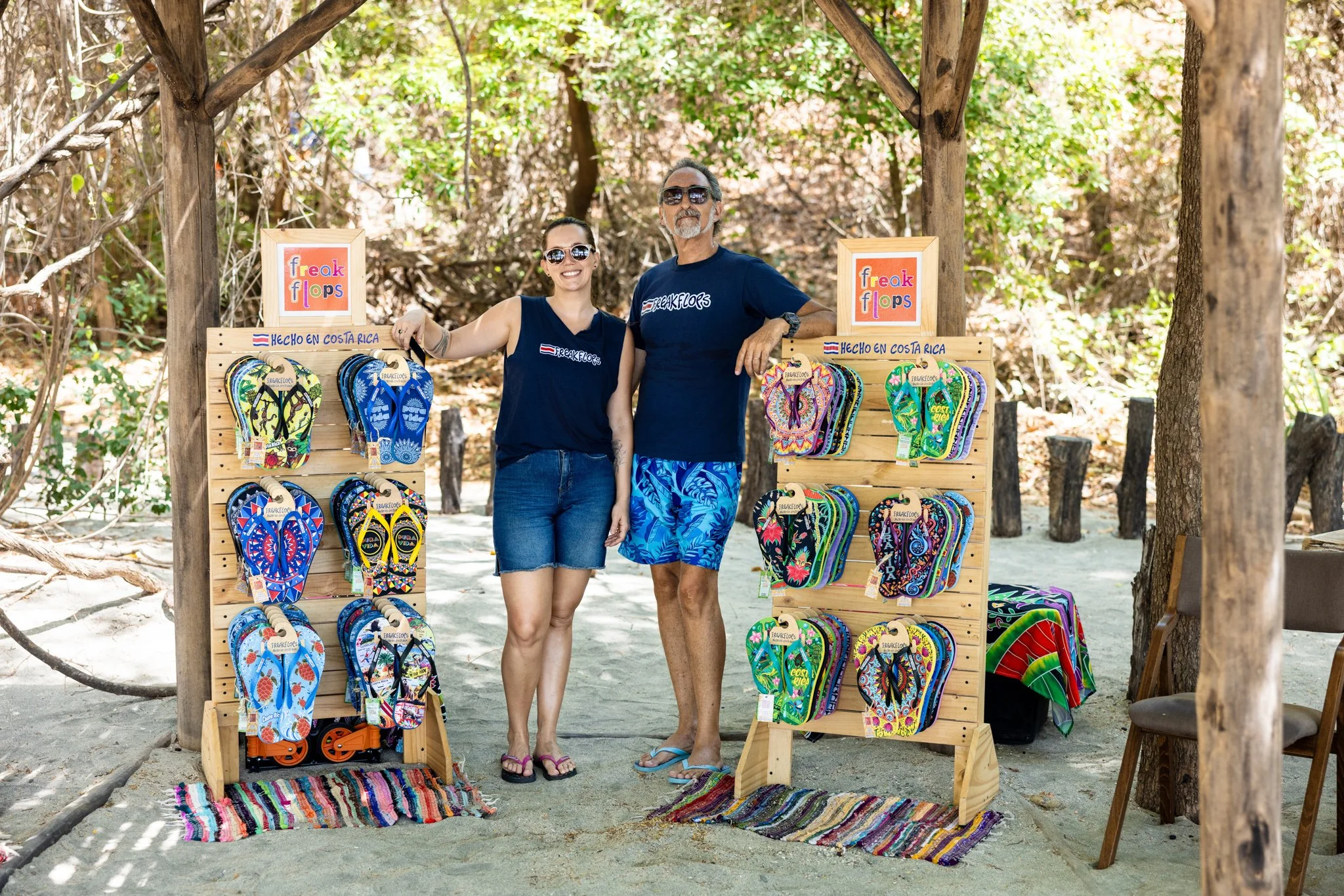 Small business branding photography; owners posing with their sandal product on a beach