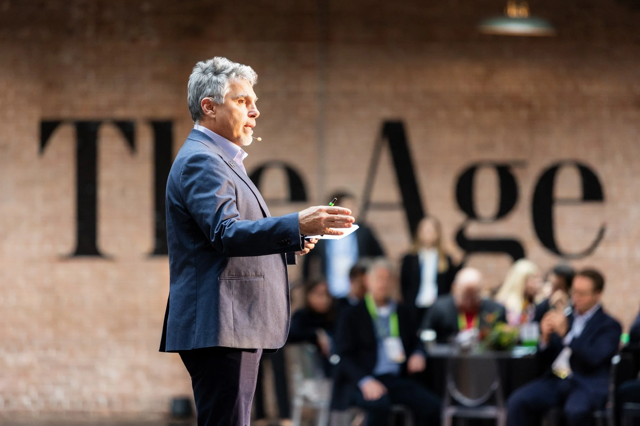 Speaker gesturing to audience during Chicago business gathering 