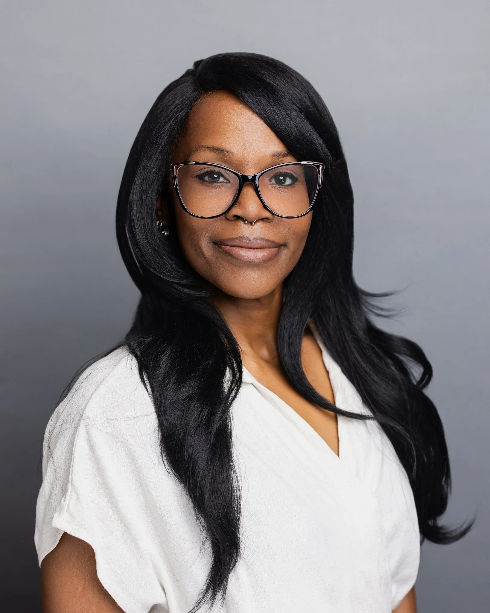 Professional headshot of an African American woman on a gray background