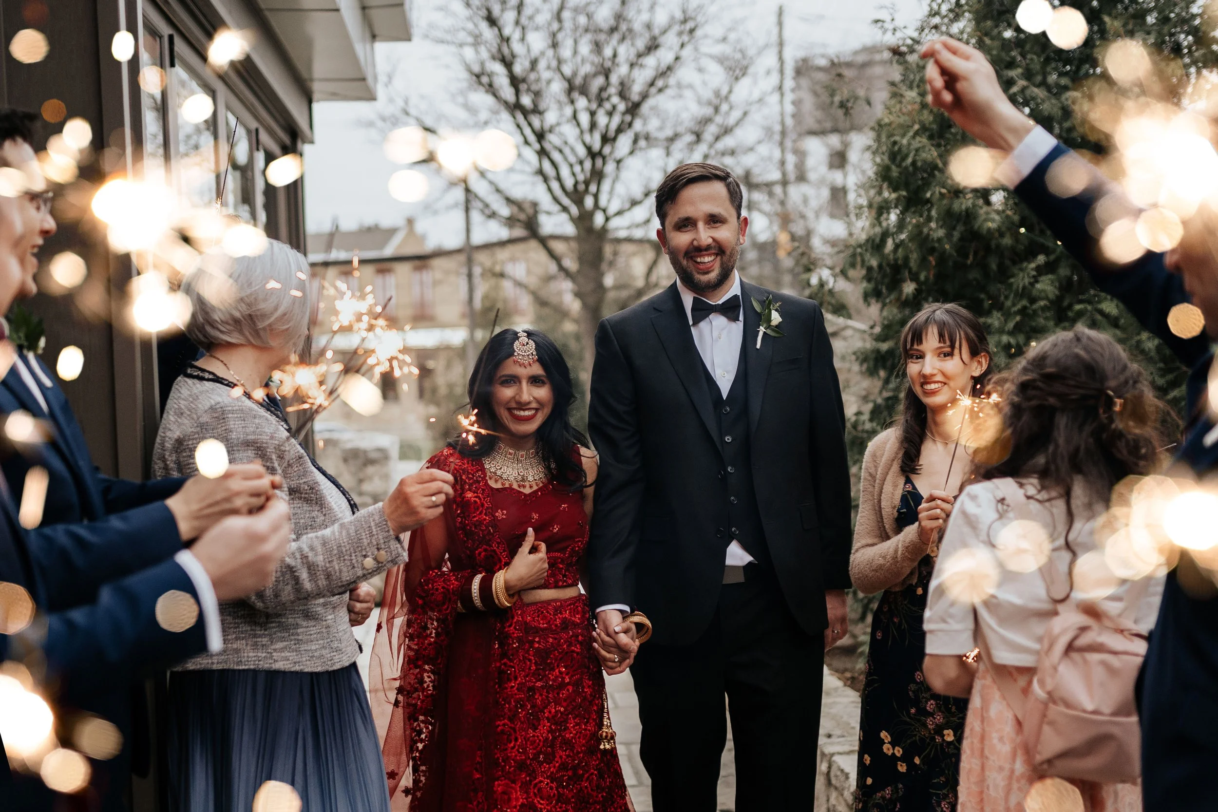 bride and groom walk through sparklers with guests and inTUNE Wedding DJs