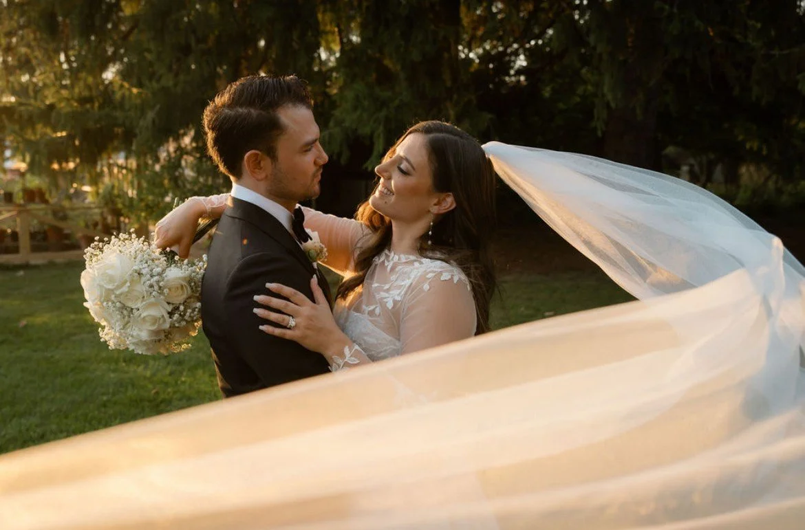 Bride and groom embracing during golden hour with flowing veil and inTUNE Niagara wedding DJs