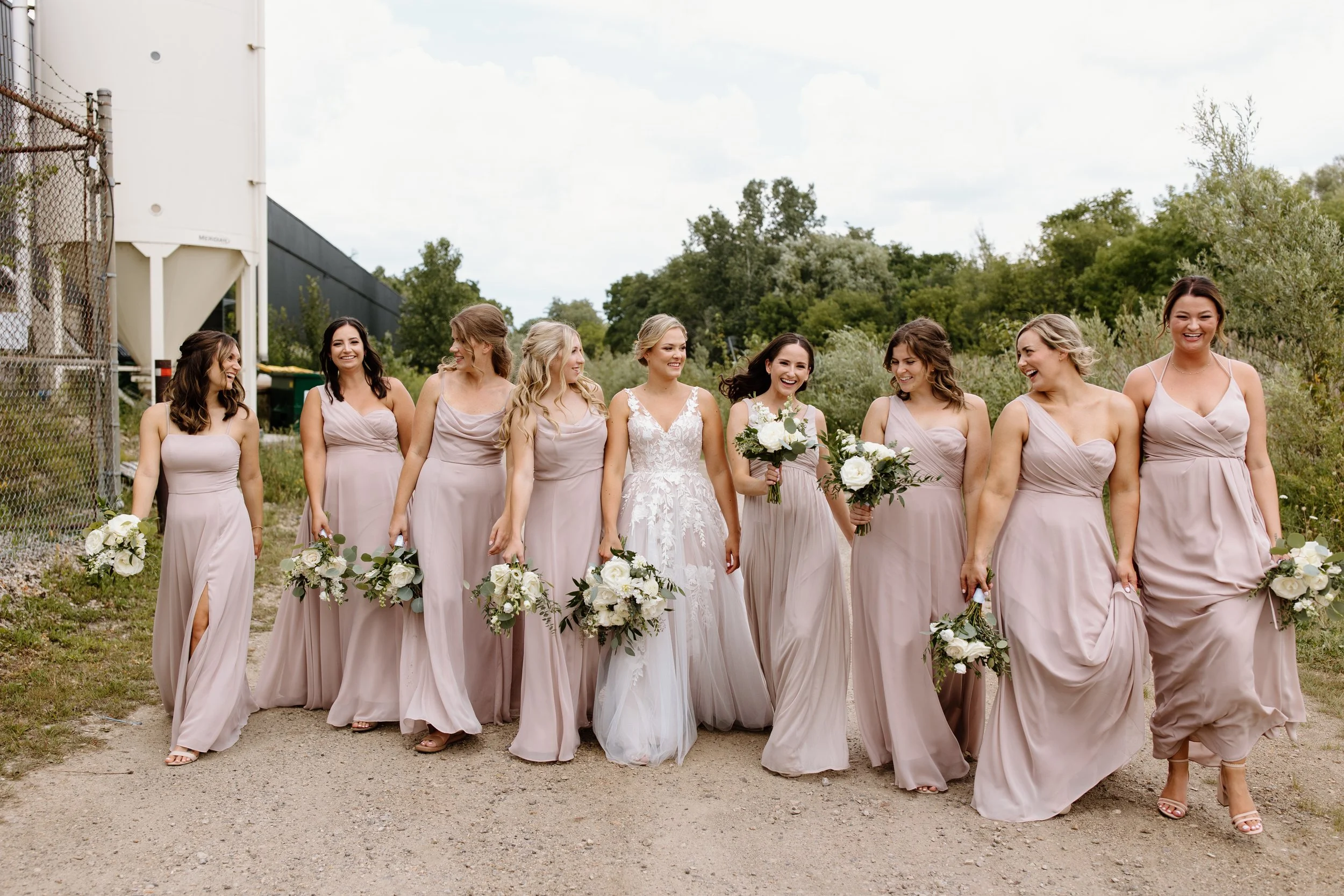 bride with bridesmaids walking laughing and having fun