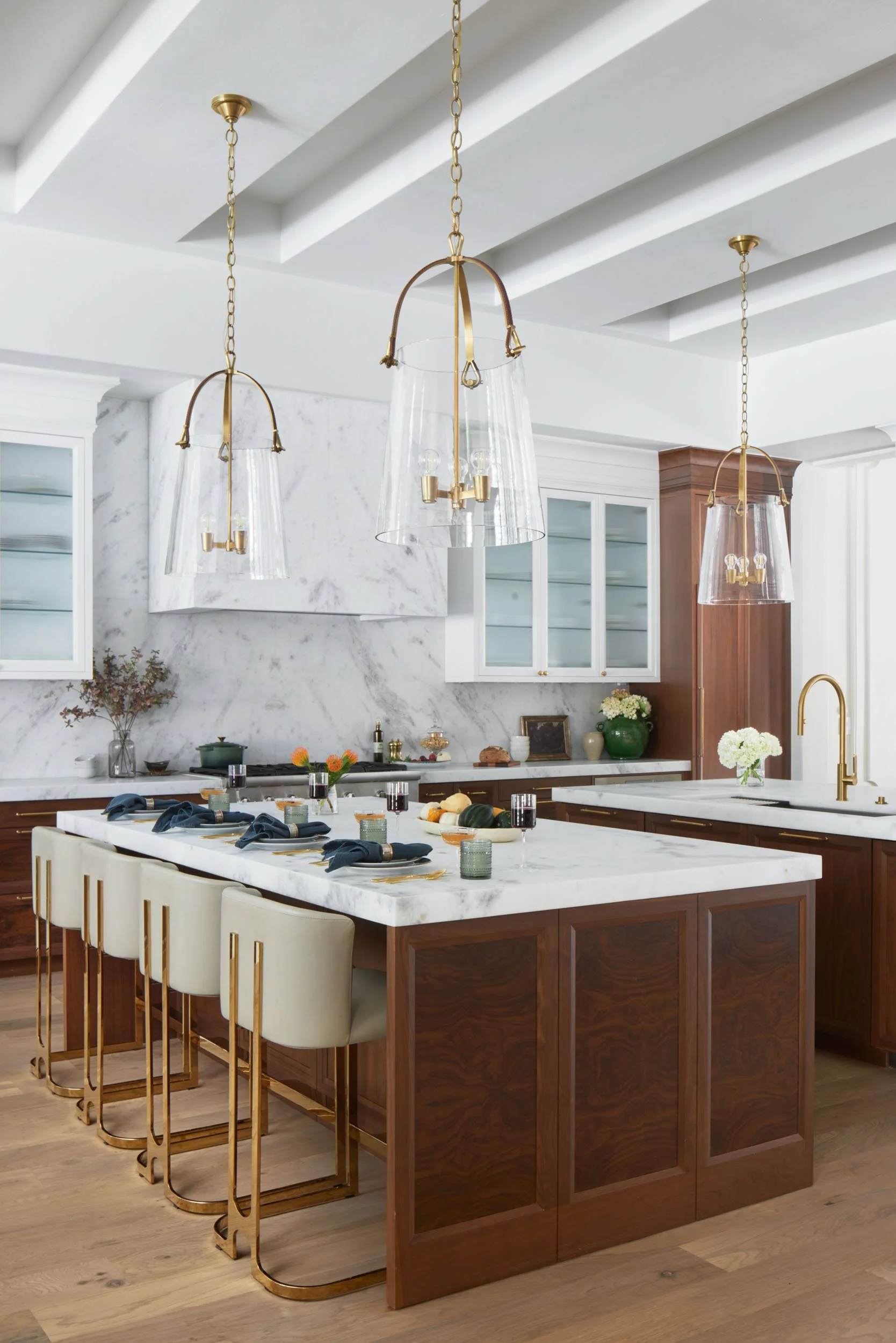  White marble kitchen countertops with wood cabinetry and decor items.  