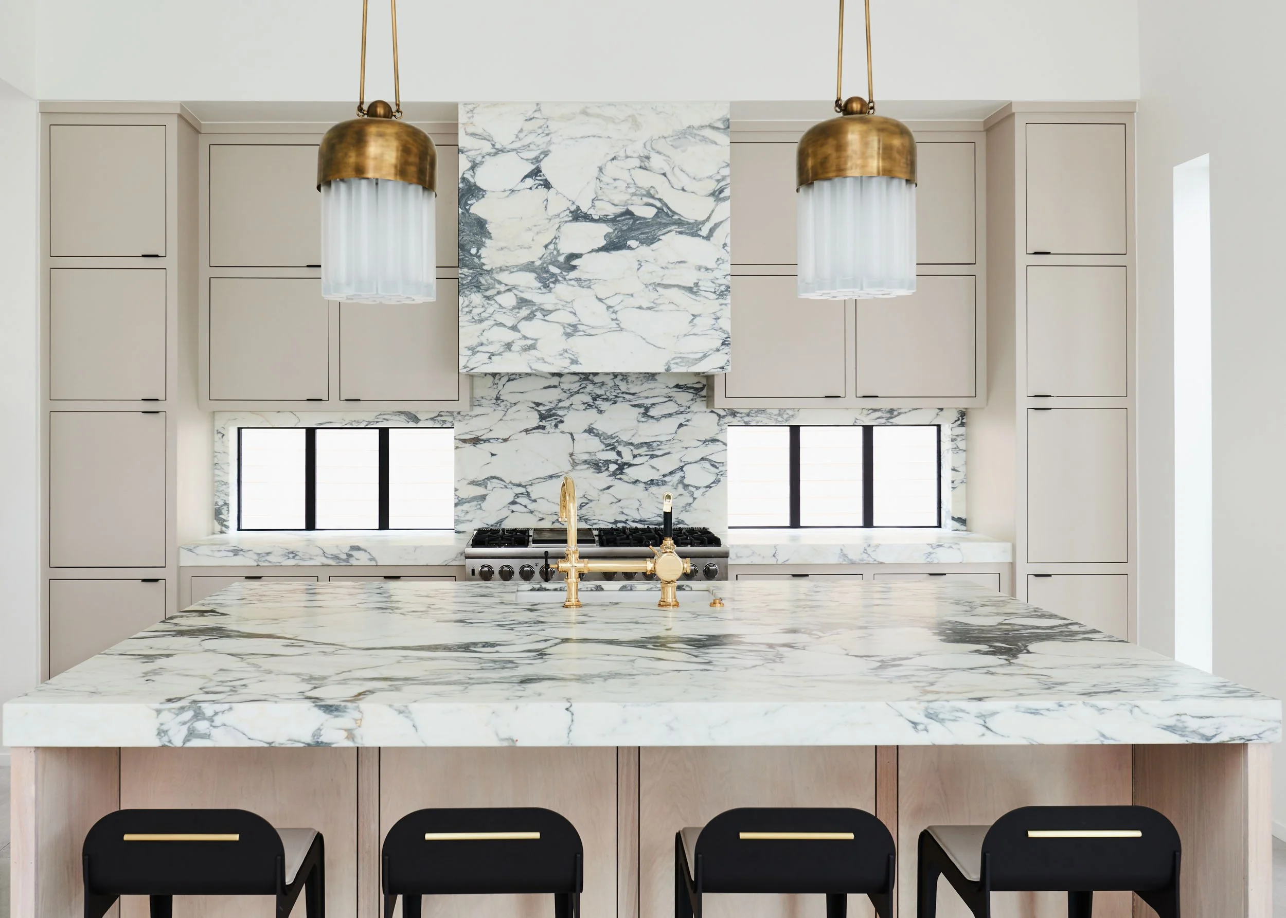  Marble countertops, backsplash, and kitchen hood with gold accents.  