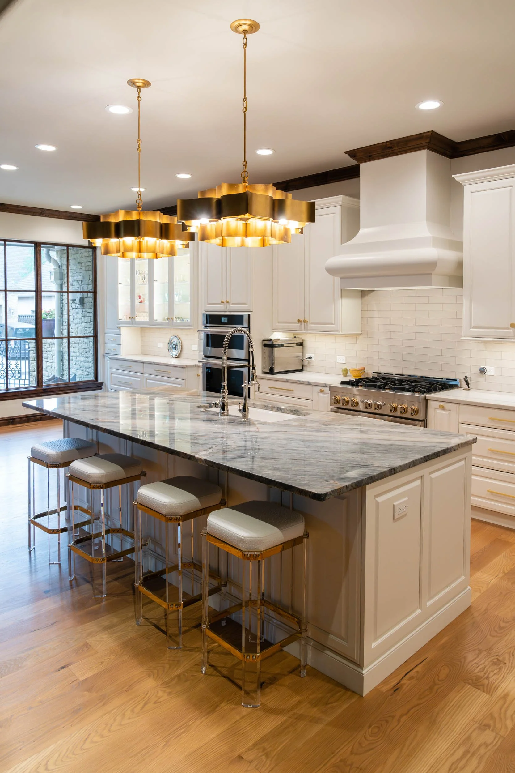  Marble countertop installation with overhead lighting and white cabinets.  