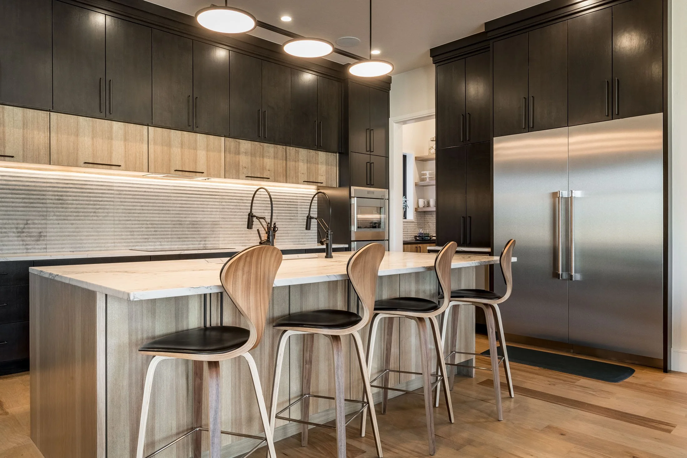  Kitchen countertops with light and dark wood accents and silver appliances.  