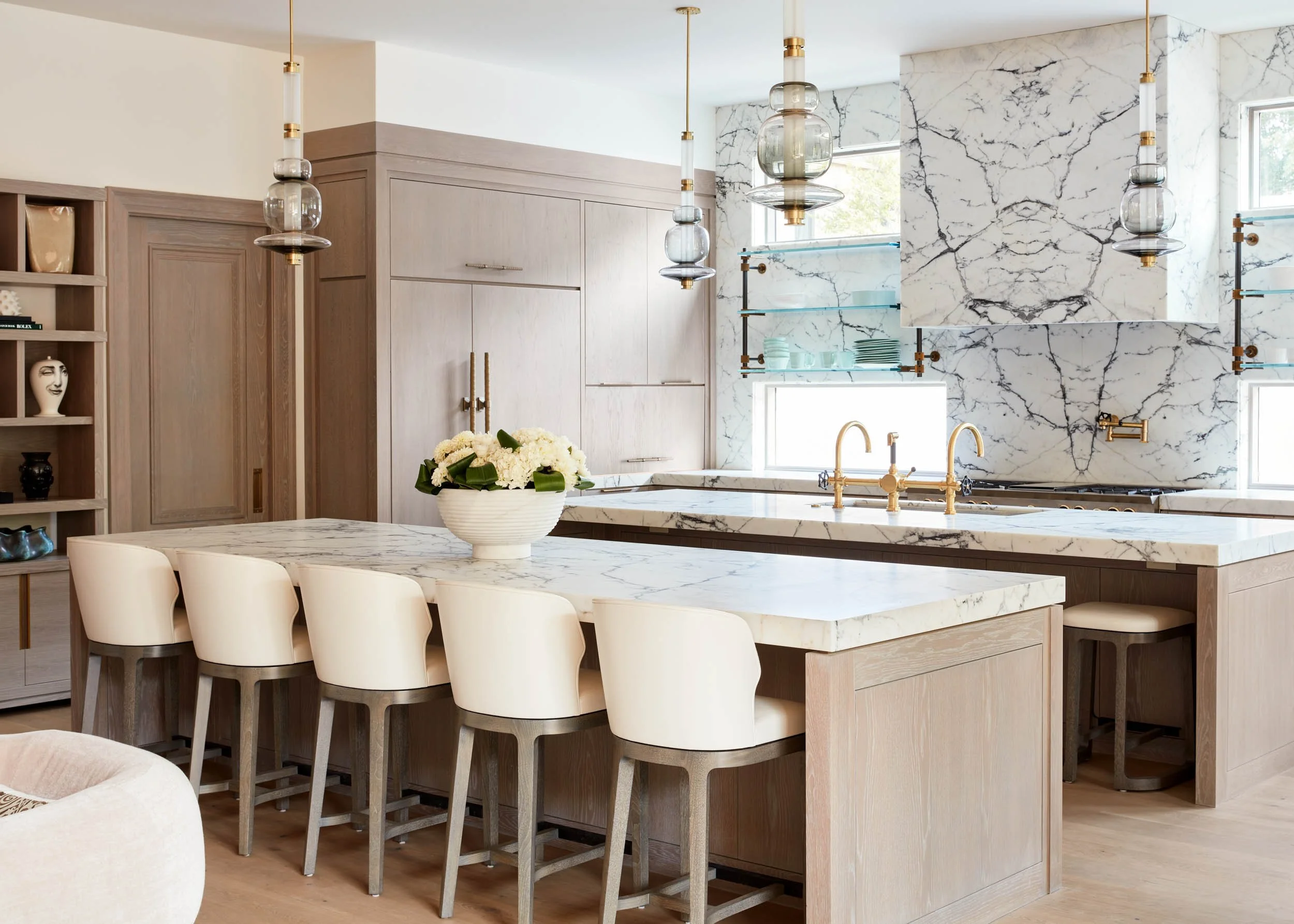  Marble countertops with matching wall and kitchen hood. Accented with gold fixtures and other decor items.  