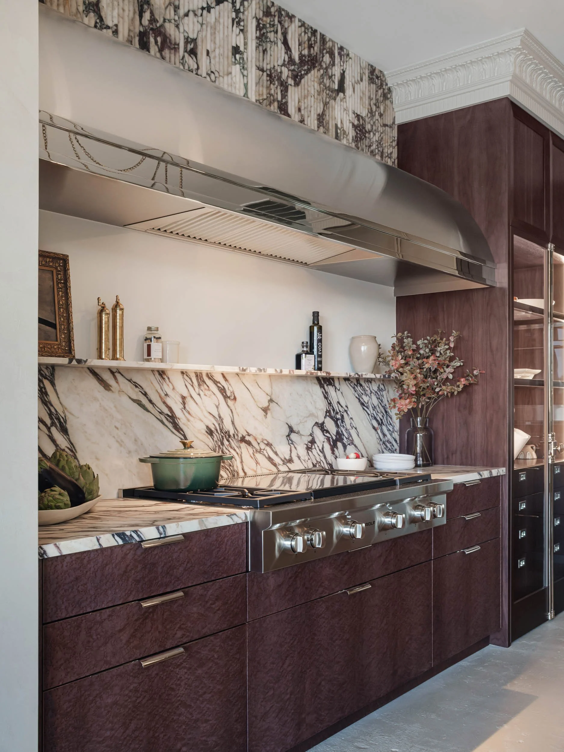  Marble countertops with matching backsplash, purple cabinets and other decor items.  