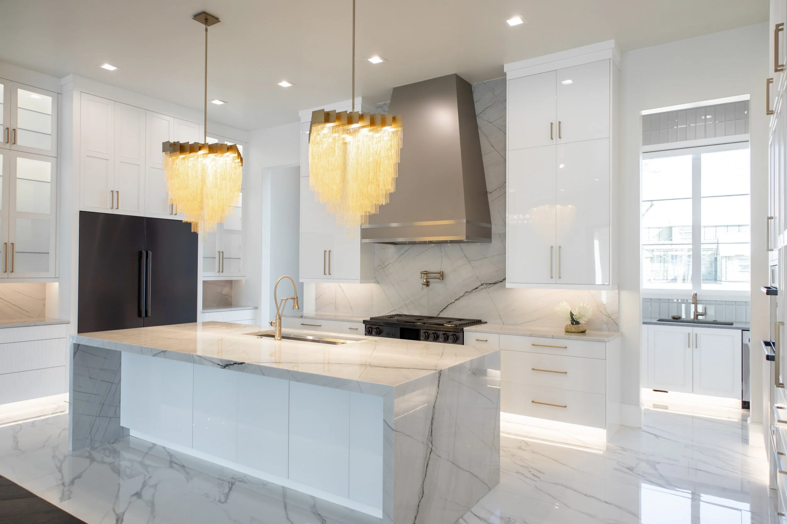  Countertop installation with black appliances and large chandeliers.  