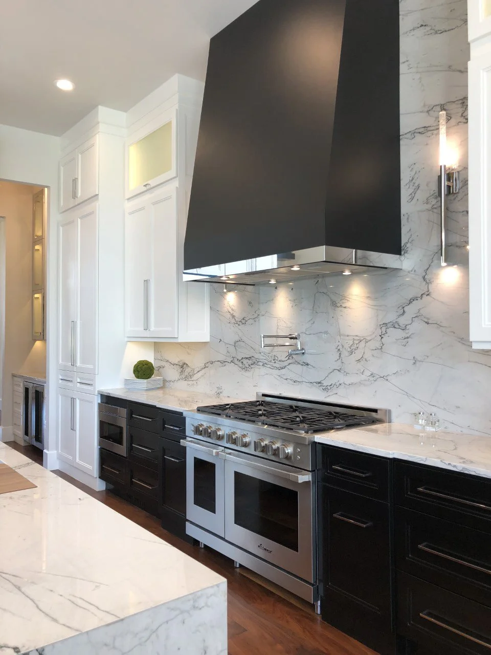  Marble countertops with black cabinets and silver appliances.  