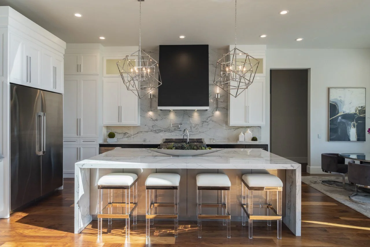  Kitchen with marble countertops, black cabinets, and large light fixtures.  