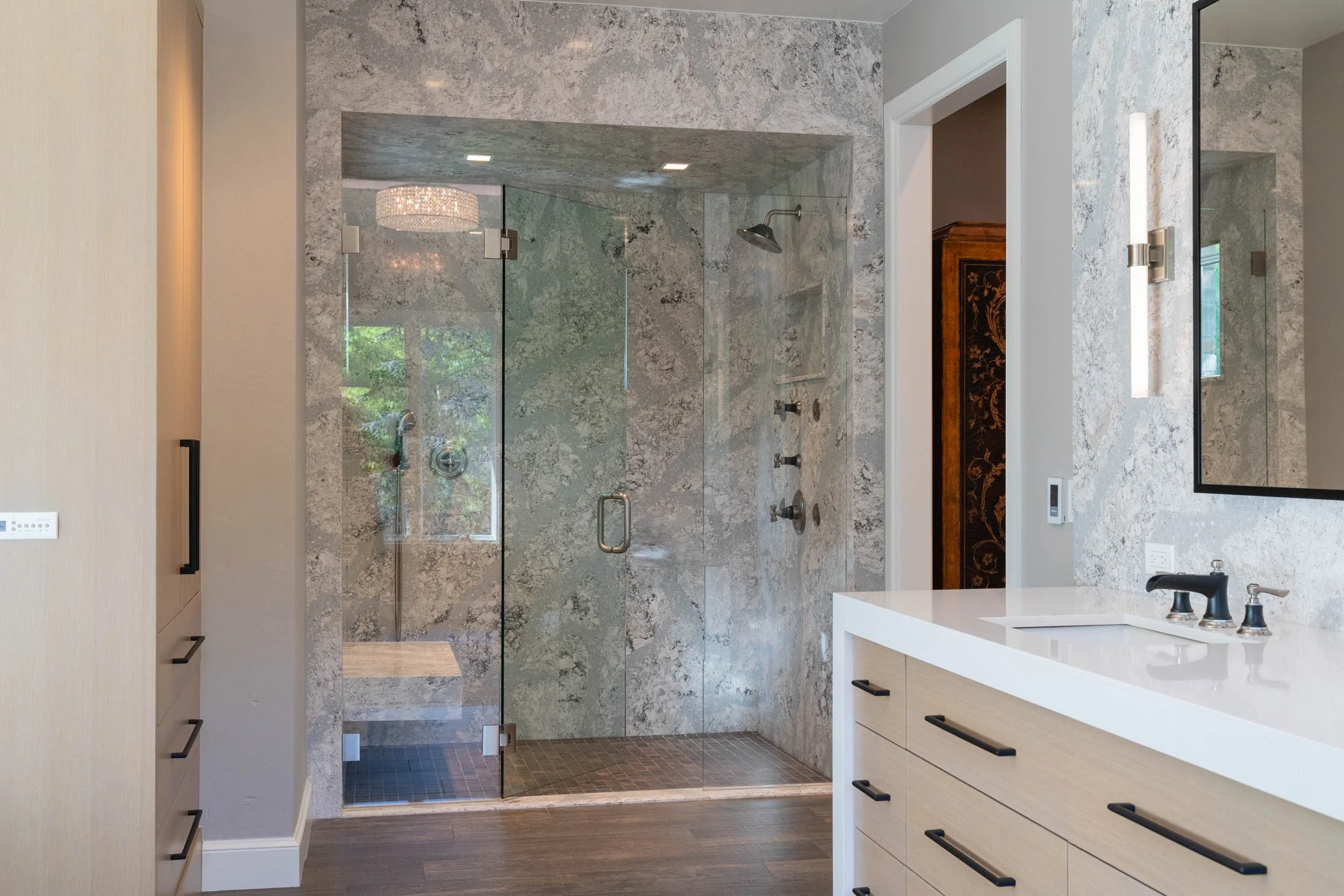  Shower wall and bench installation with light wood cabinetry.  