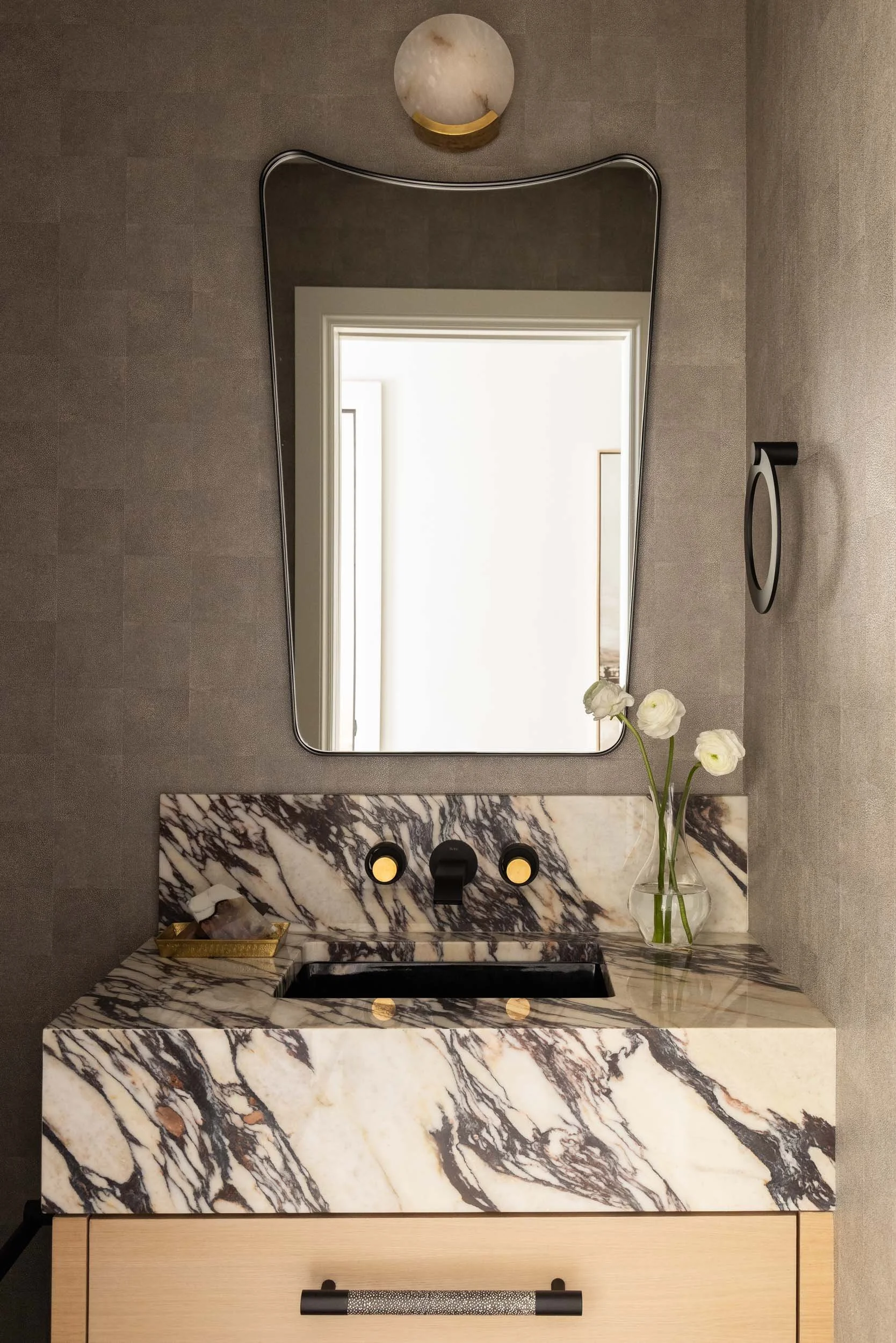  Powder bathroom with marble countertops and large mirror.  