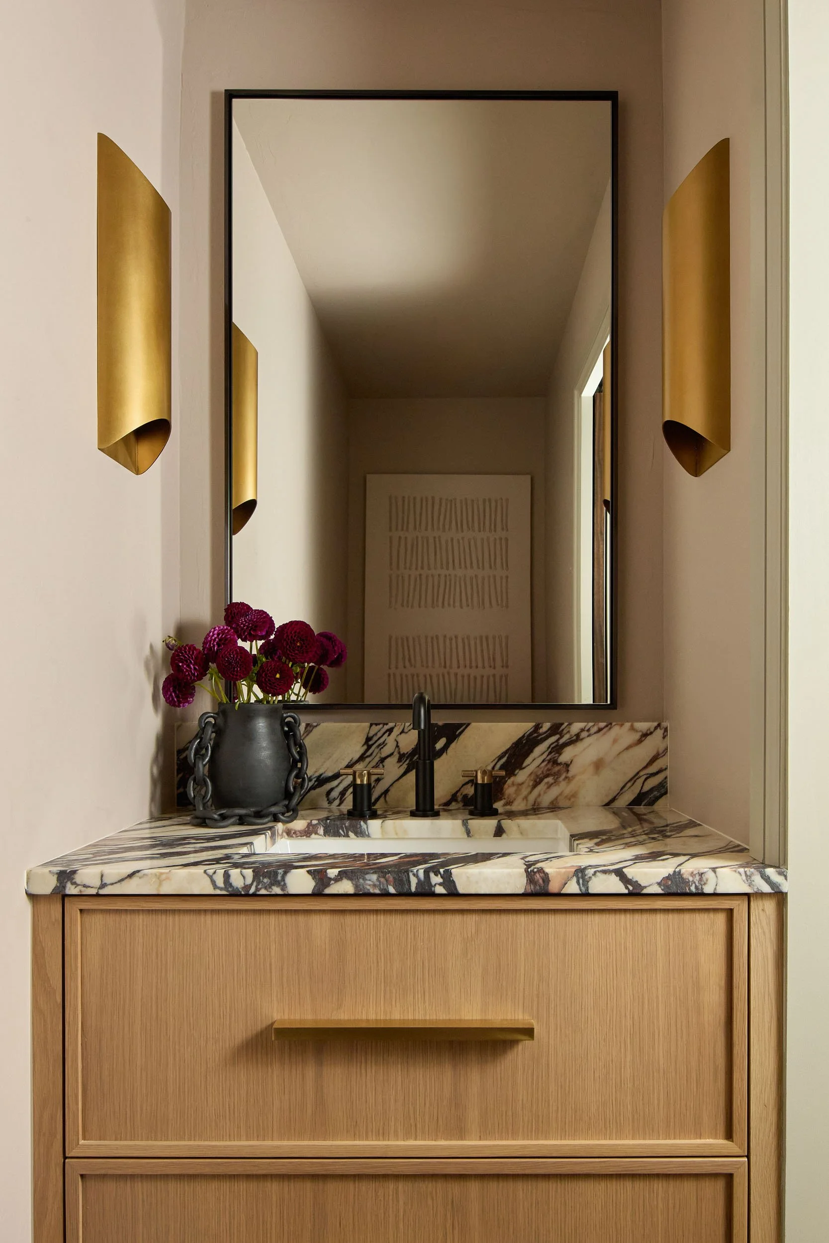  Powder bath with marble countertops and large mirror.  